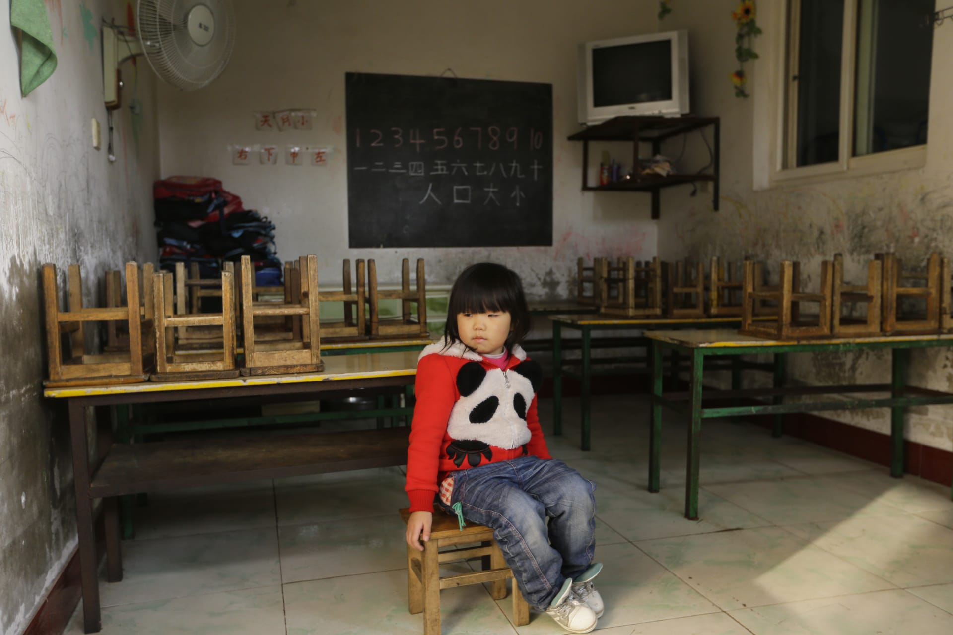 <p>A girl sits on a chair in a class at a kindergarten, a school for children of migrant workers, on the outskirts of Beijing November 8, 2013.</p>
