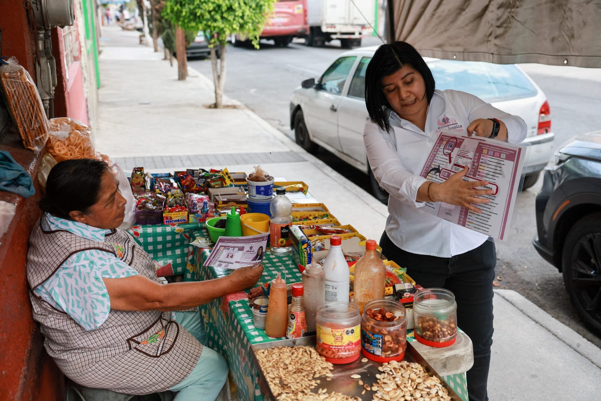 Alma Jessica Morales, candidate for Civil Magistrate, shows a woman a ballot during her campaign ahead of the June 1 judicial and magistrate elections, when voters will decide who should serve as judges, in Mexico City