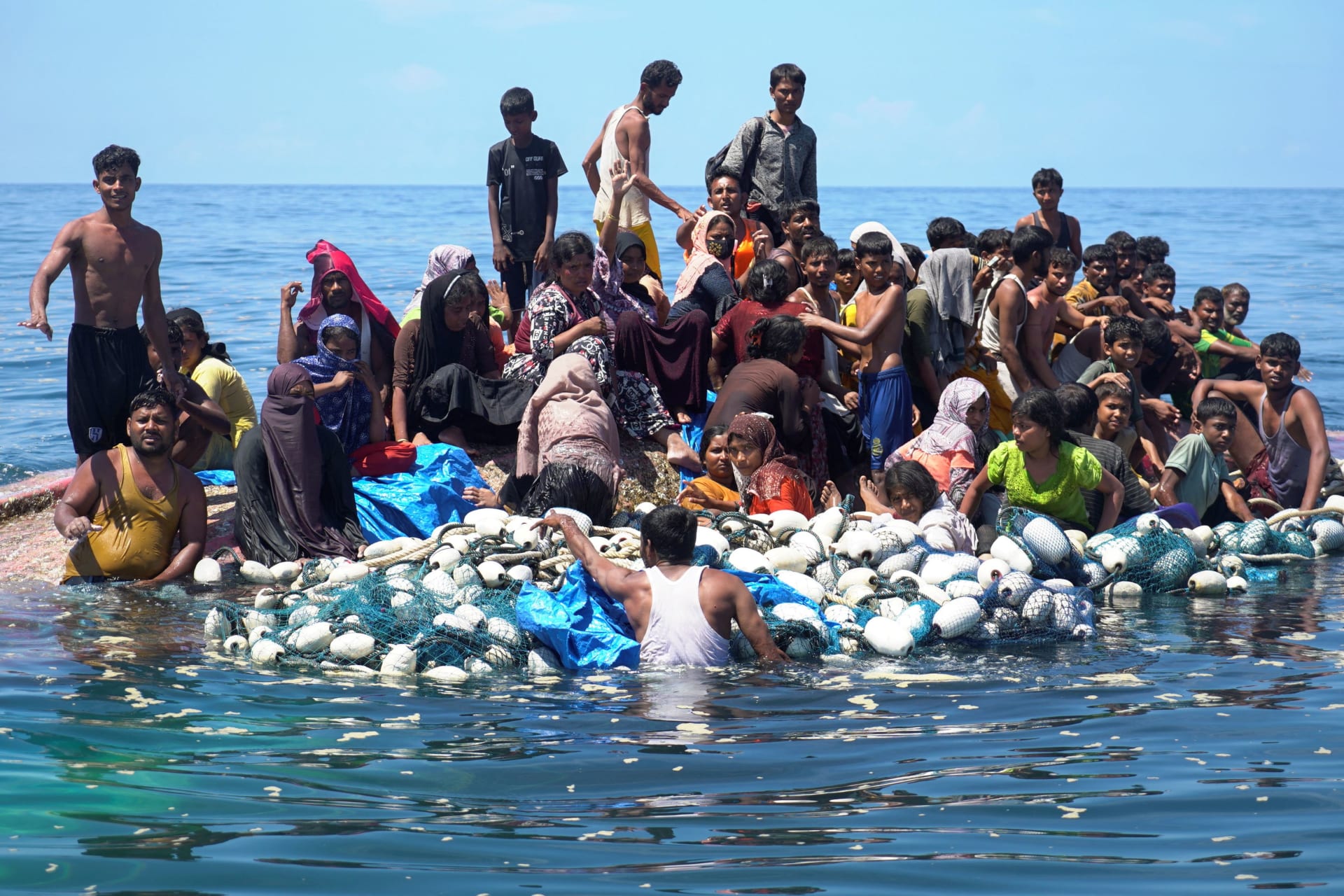 <p>Rohingya refugees stand on a capsized boat before being rescued in the waters of West Aceh, Indonesia on March 21, 2024.</p>
