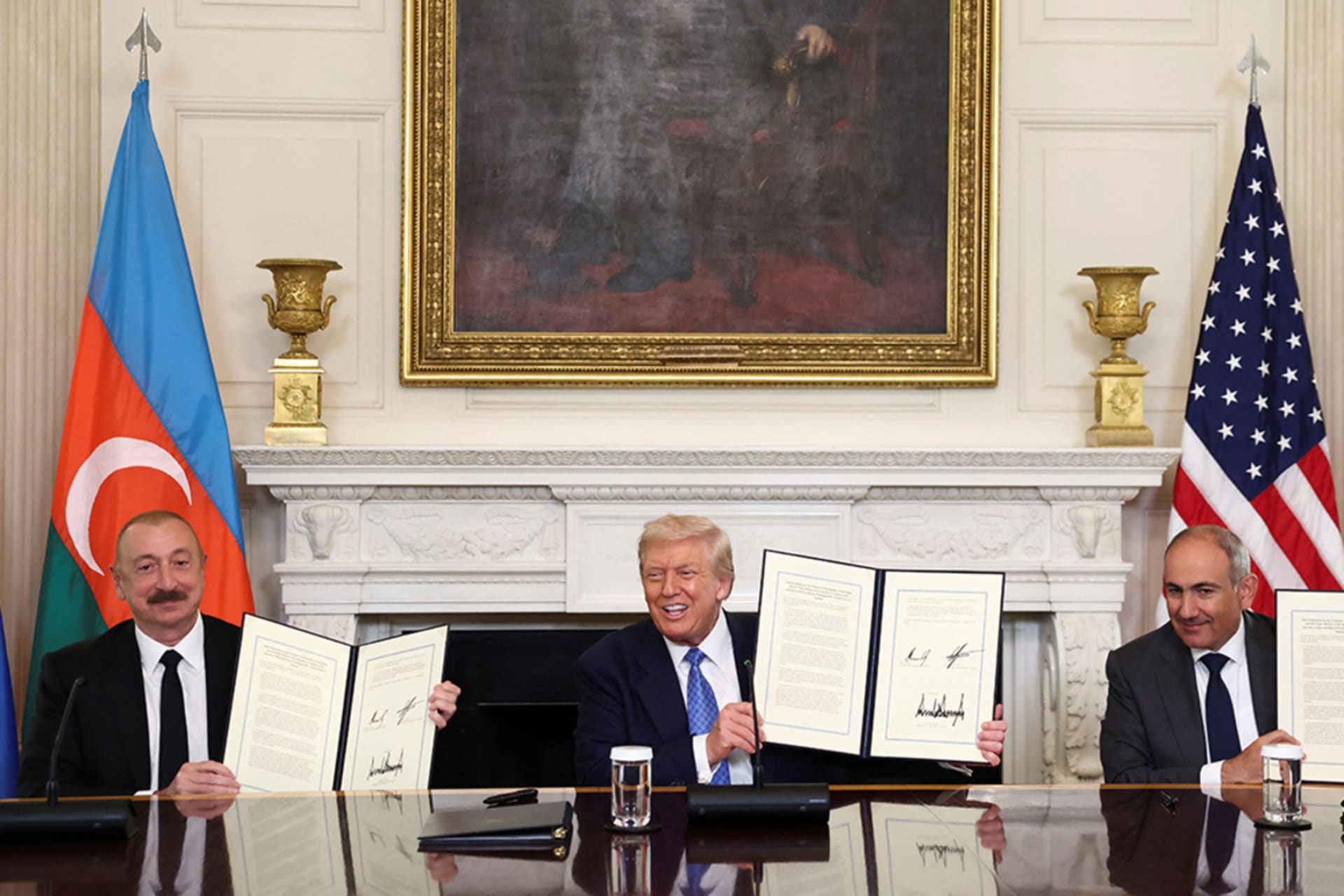 <p> Azerbaijani President Ilham Aliyev, U.S. President Donald Trump, and Armenian Prime Minister Nikol Pashinyan hold up their signed agreements at the White House on August 8.</p>
