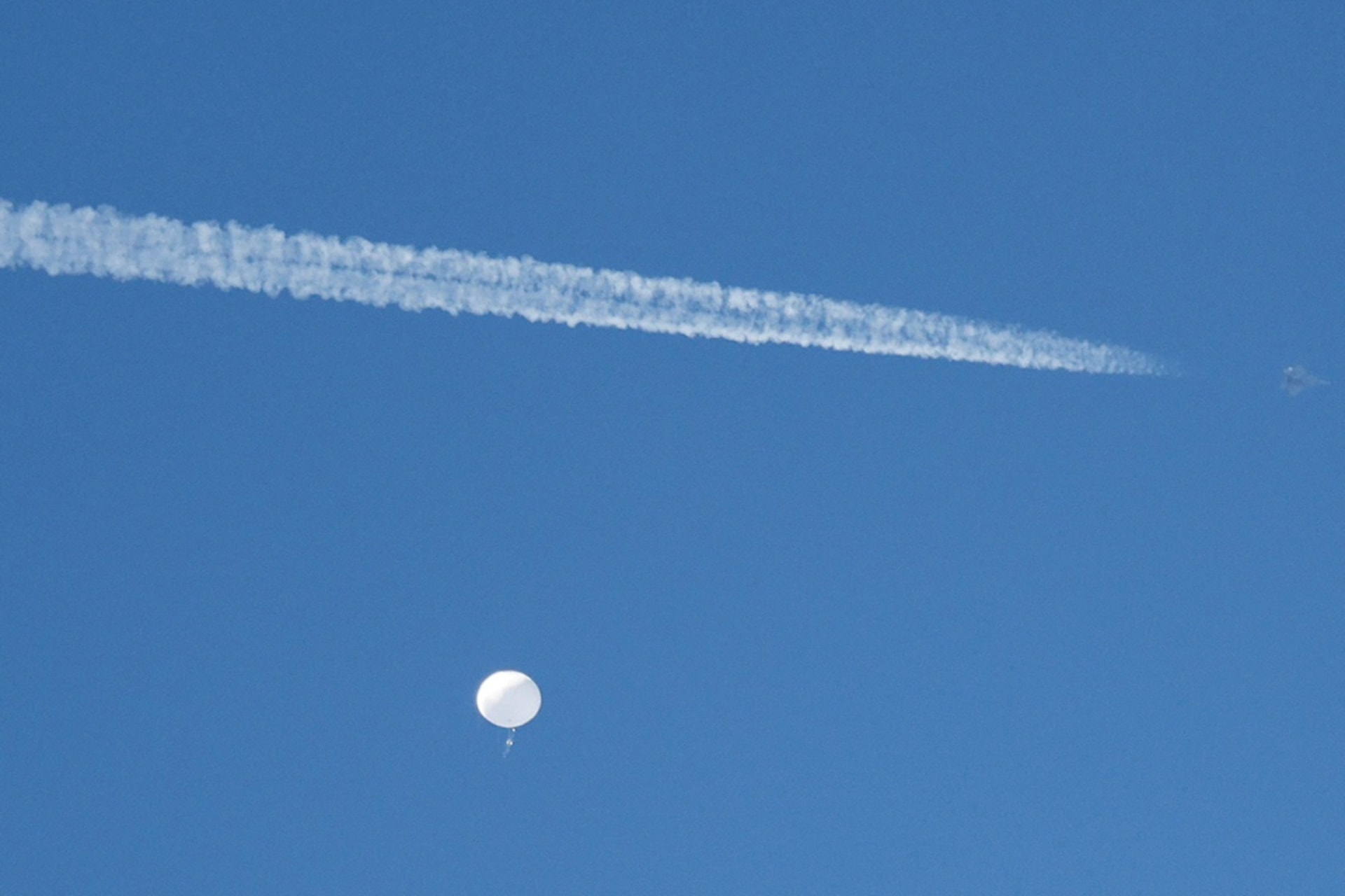 <p>A jet flies by a suspected Chinese spy balloon as it floats off the coast in Surfside Beach, S.C., on Saturday. </p>
