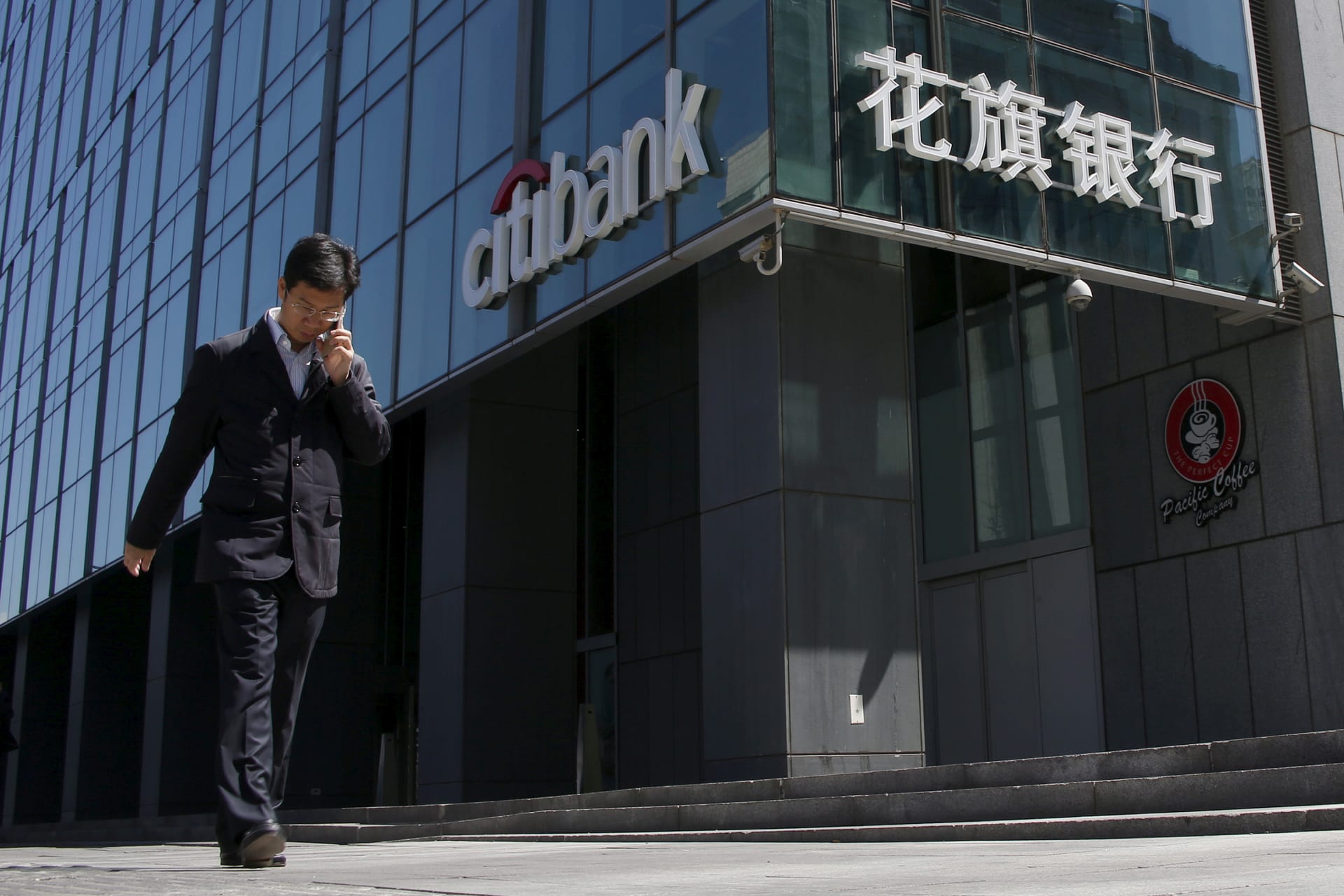 <p>A man walks past a branch of Citibank in Beijing, on April 18, 2016.</p>