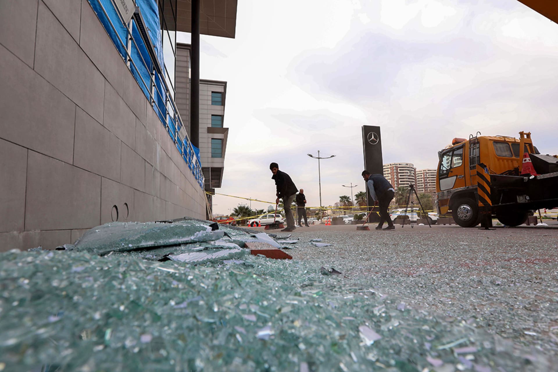 A worker sweeps shattered glass outside a damaged shop following a rocket attack in Erbil, the capital of Iraqi Kurdistan. 
