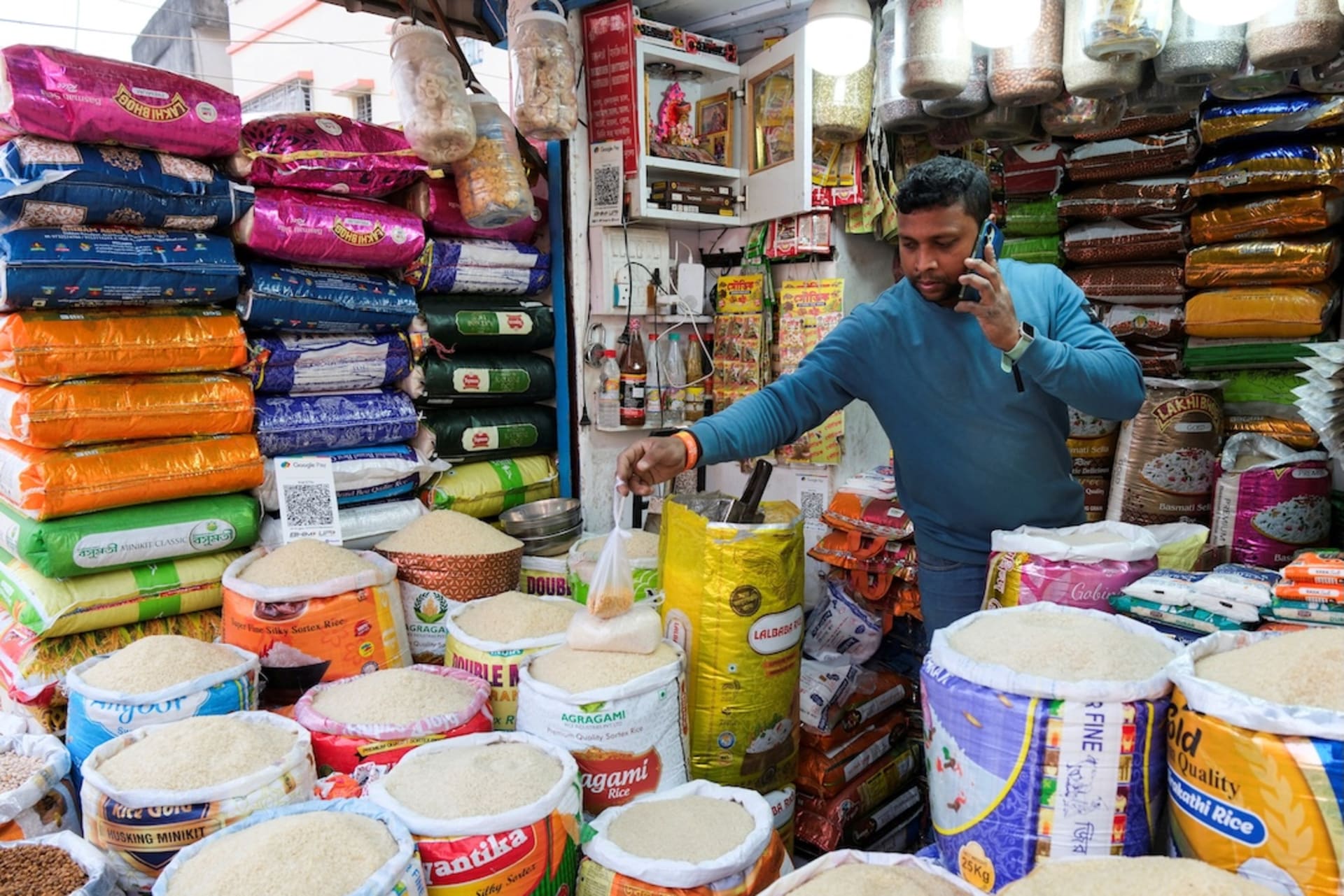 <p>A shopkeeper speaks on the phone as he sells rice and grains inside a wholesale market in Kolkata, India, January 13, 2026.</p>

