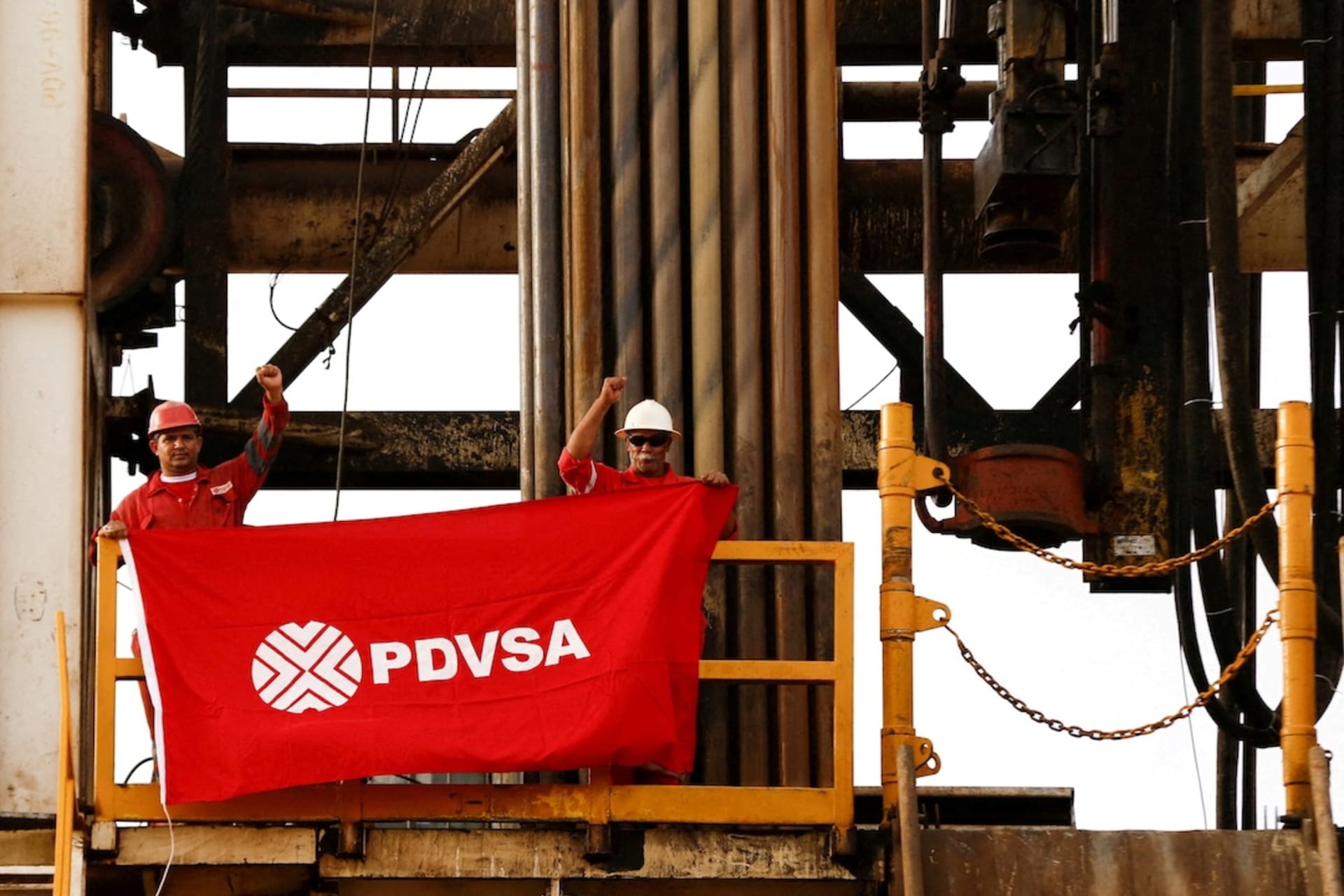 <p>Oilfield workers hold a flag with the corporate logo of Venezuela’s state oil company PDVSA on a drilling rig at an oil well operated by them in the Orinoco belt, near Cabrutica, Anzoategui, April 16, 2015.</p>