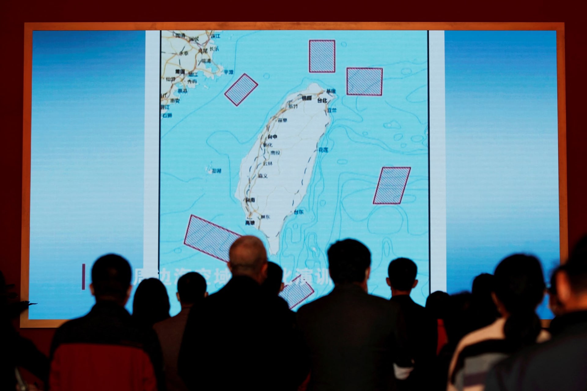 <p>Visitors stand in front of a giant screen displaying a map of locations around Taiwan where the Chinese People’s Liberation Army (PLA) conducted military exercises in August 2022.</p>
