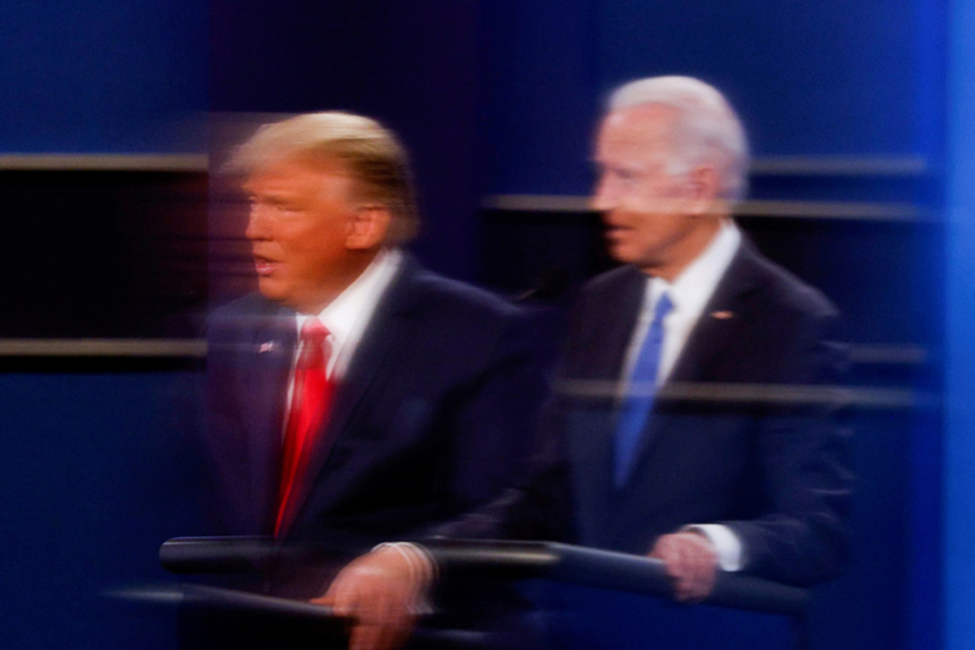 <p>U.S. President Donald Trump and Democratic presidential nominee Joe Biden are reflected in the plexiglass protecting a TV camera operator from coronavirus as they participate in their second 2020 presidential campaign debate </p>
