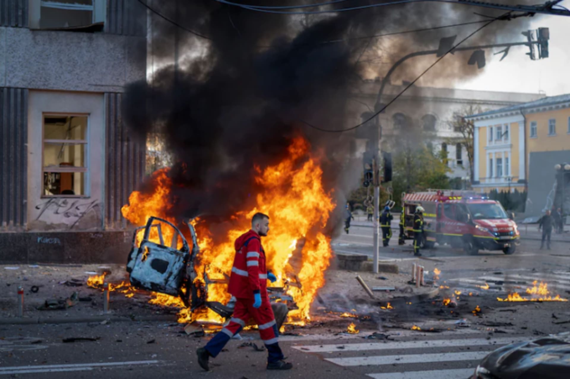 <p>A medical worker runs past a burning car after a Russian attack in Kyiv, Ukraine, on Monday. </p>
