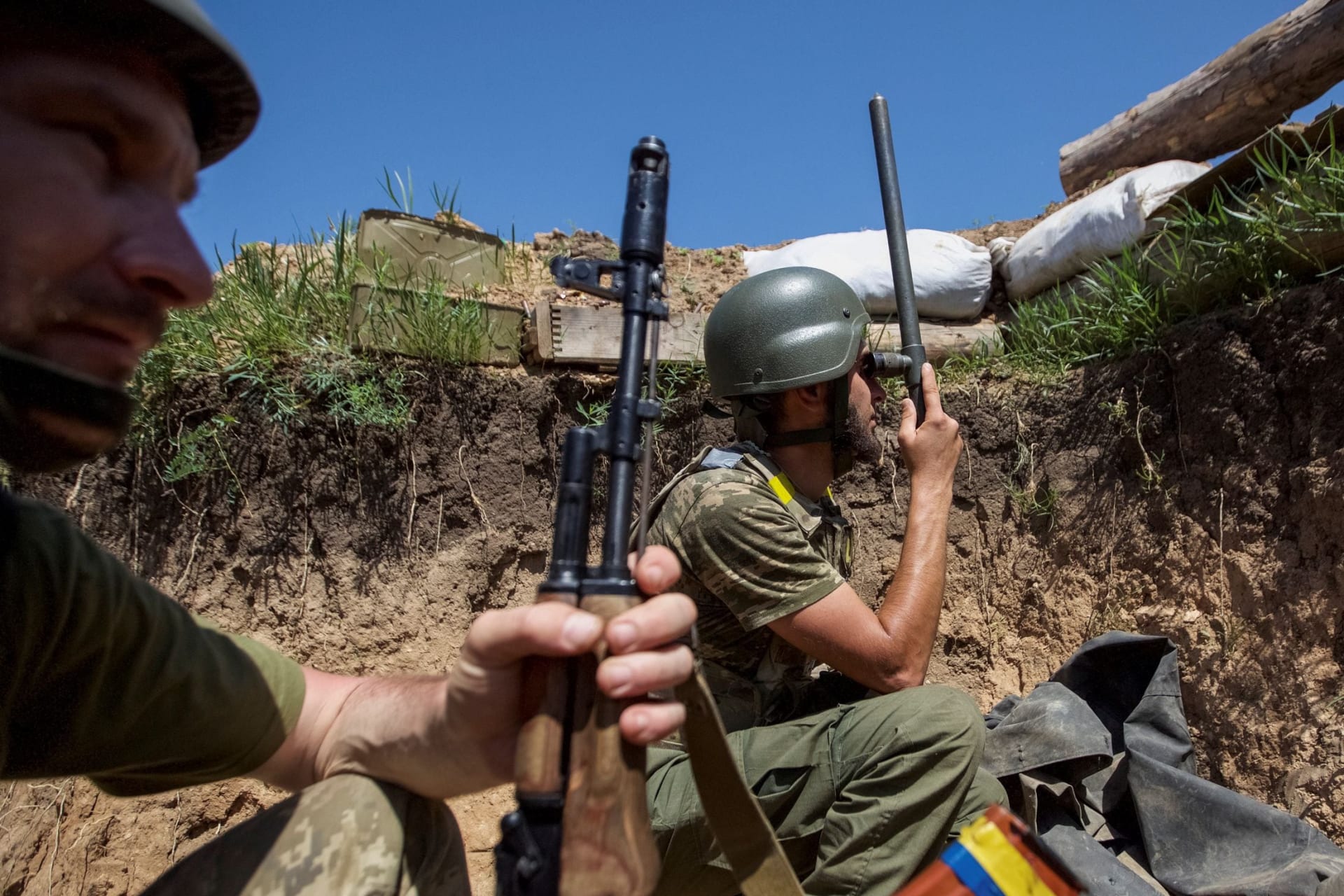 <p>Ukrainian soldier peers through binoculars on the front line in Krasnohorivka, in the Donetsk region of Ukraine, on June 3. </p>