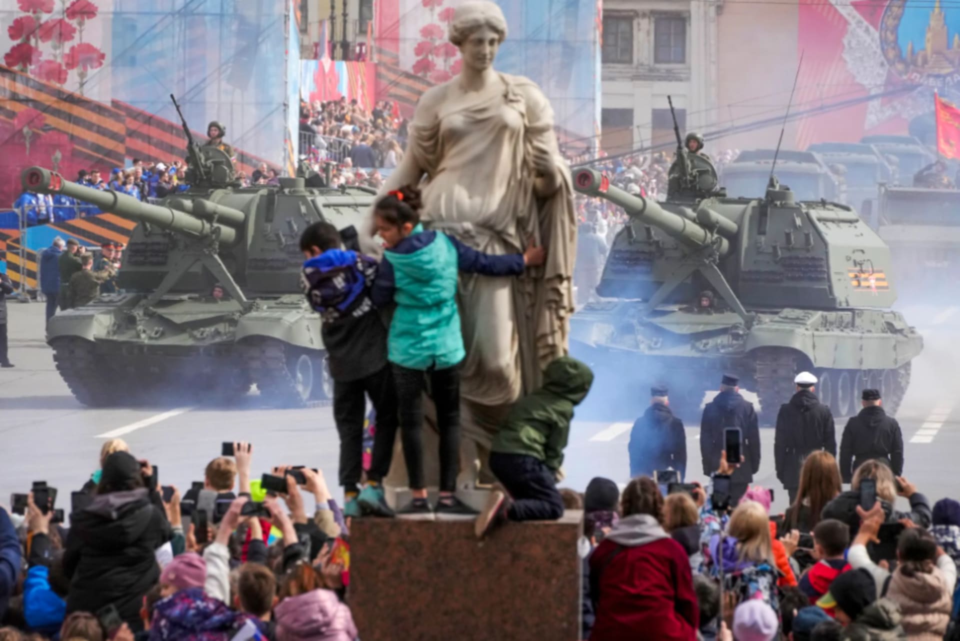 <p>People look at self-propelled artillery vehicles during the Victory Day military parade in St. Petersburg on May 9. </p>
