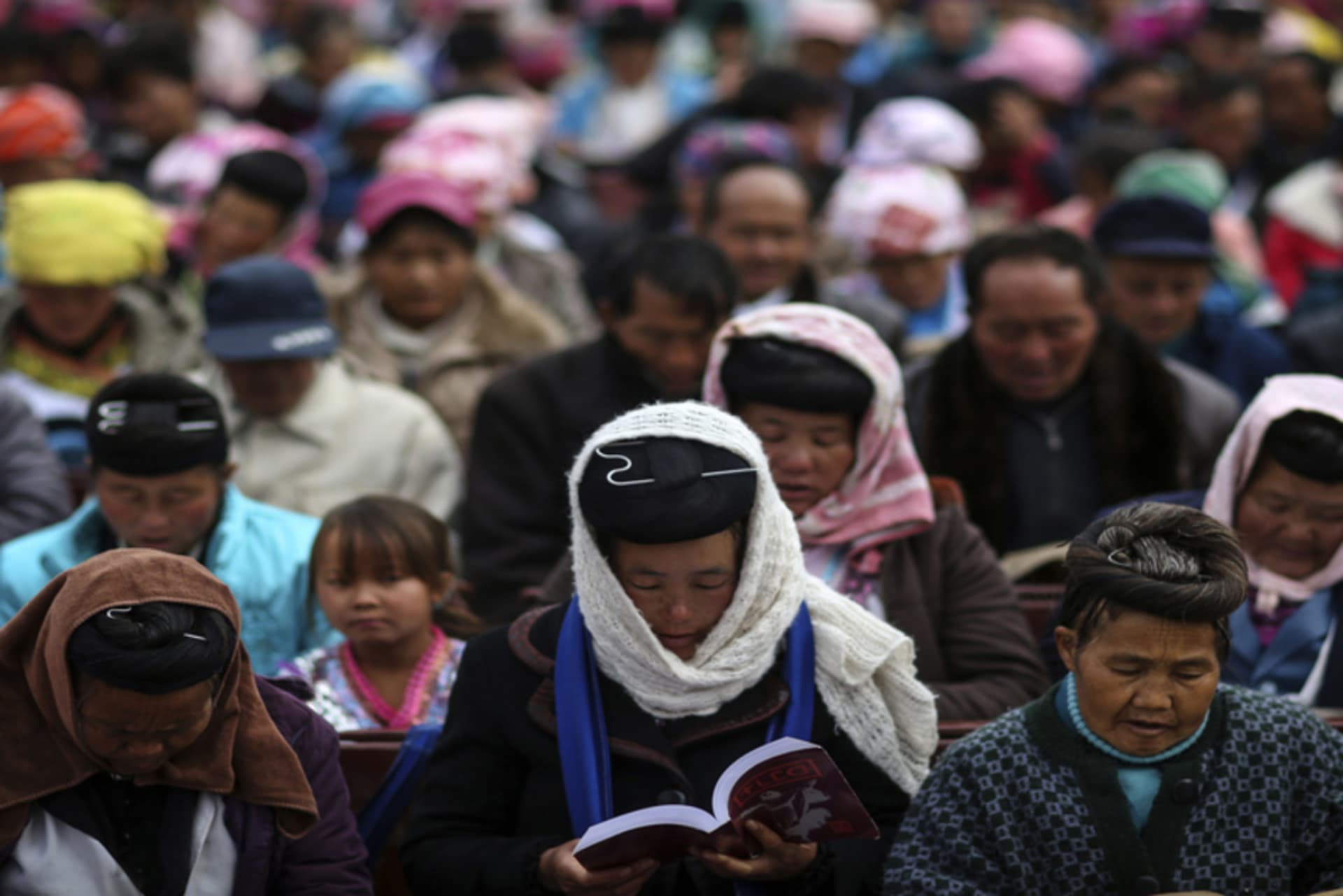 Ethnic Miao people read the Bible at a church ahead of the Christmas week at Xiaoxinzhuang