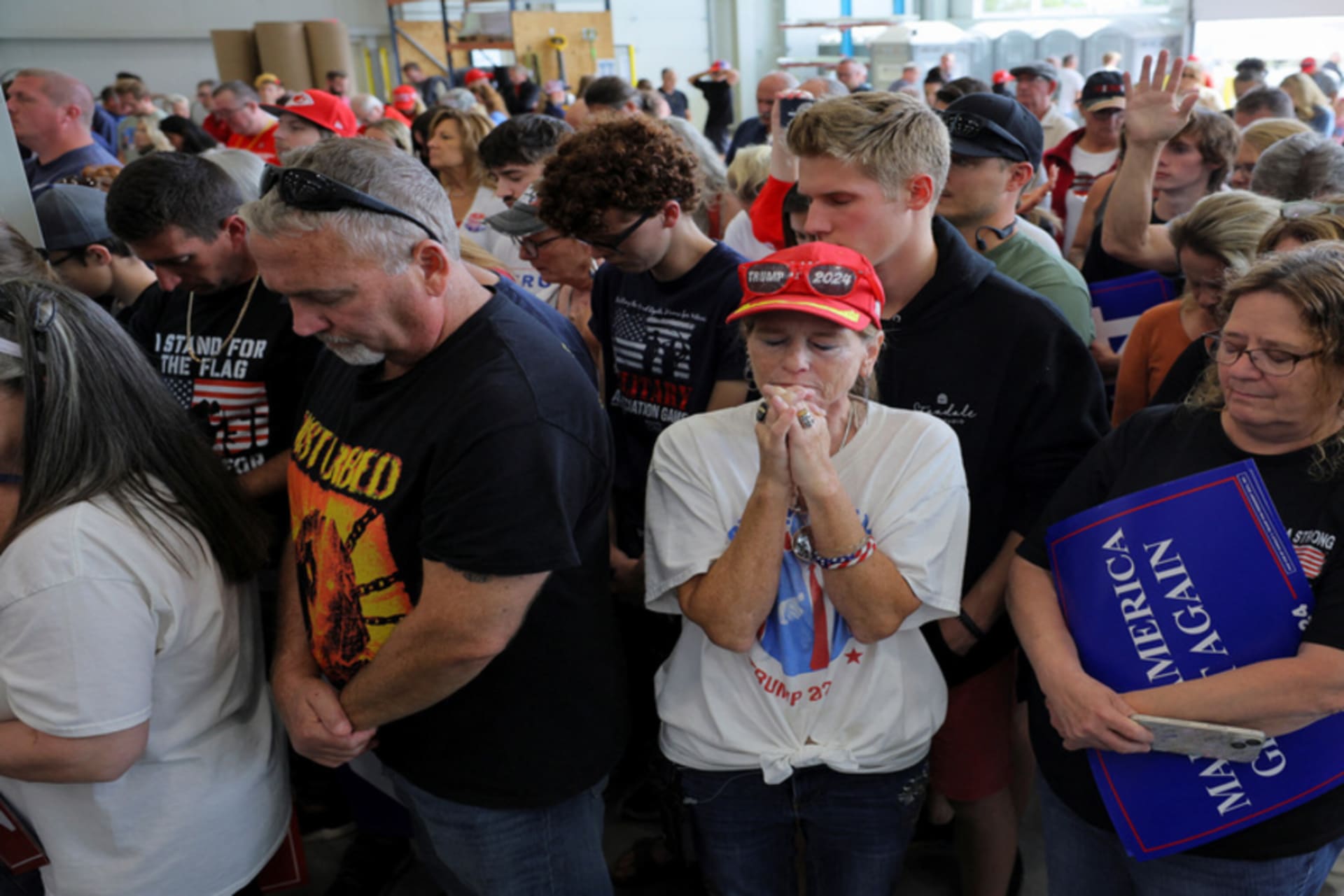 <p>Supporters of Republican presidential nominee and former U.S. President Donald Trump pray during the invocation on the day Trump makes a campaign stop at manufacturer FALK Production in Walker, Michigan, U.S. September 27, 2024.</p>
