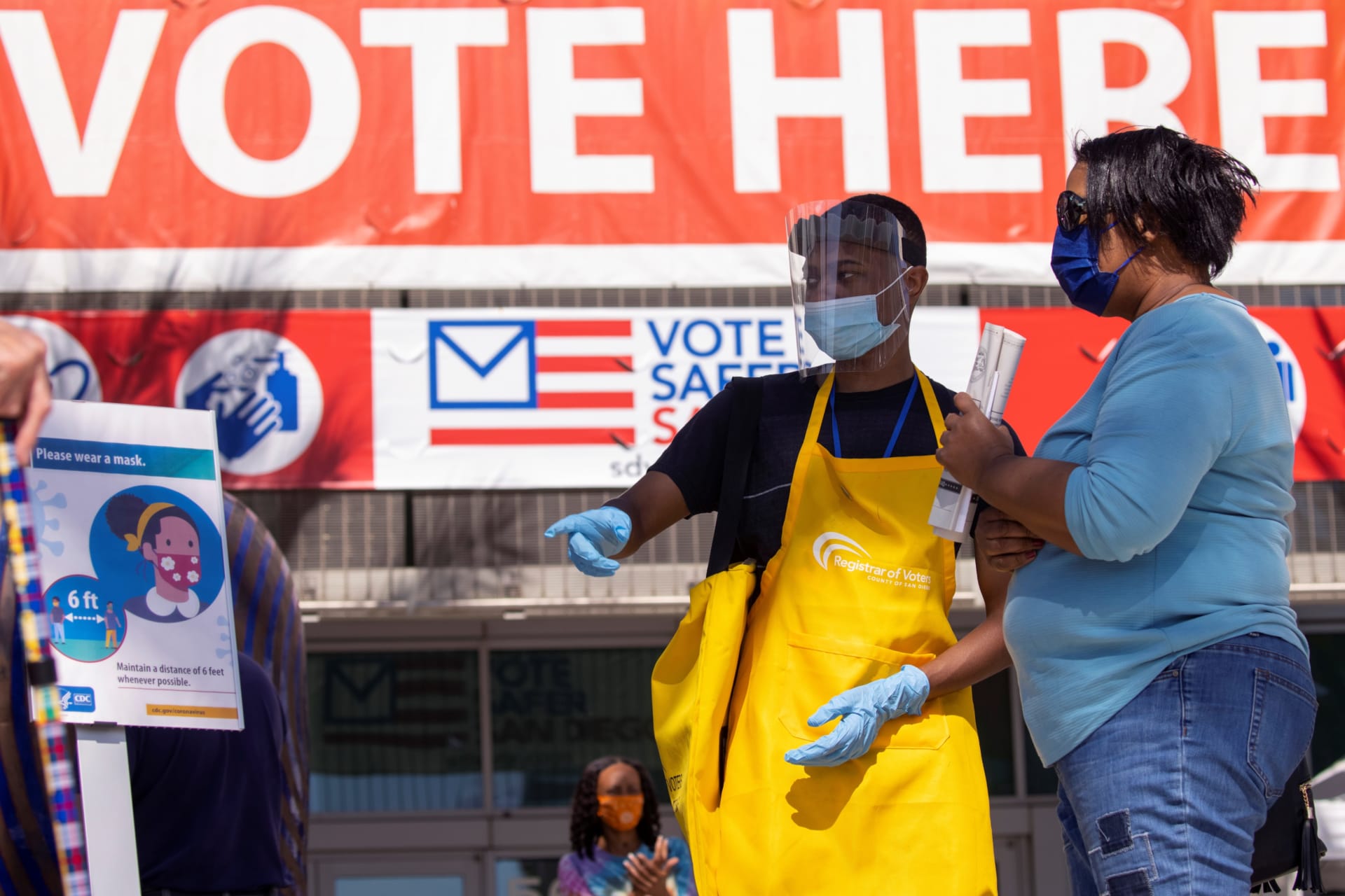 <p>An election worker guides voters where to register to vote at the Registrar of Voters for San Diego County in San Diego, California, U.S.</p>
