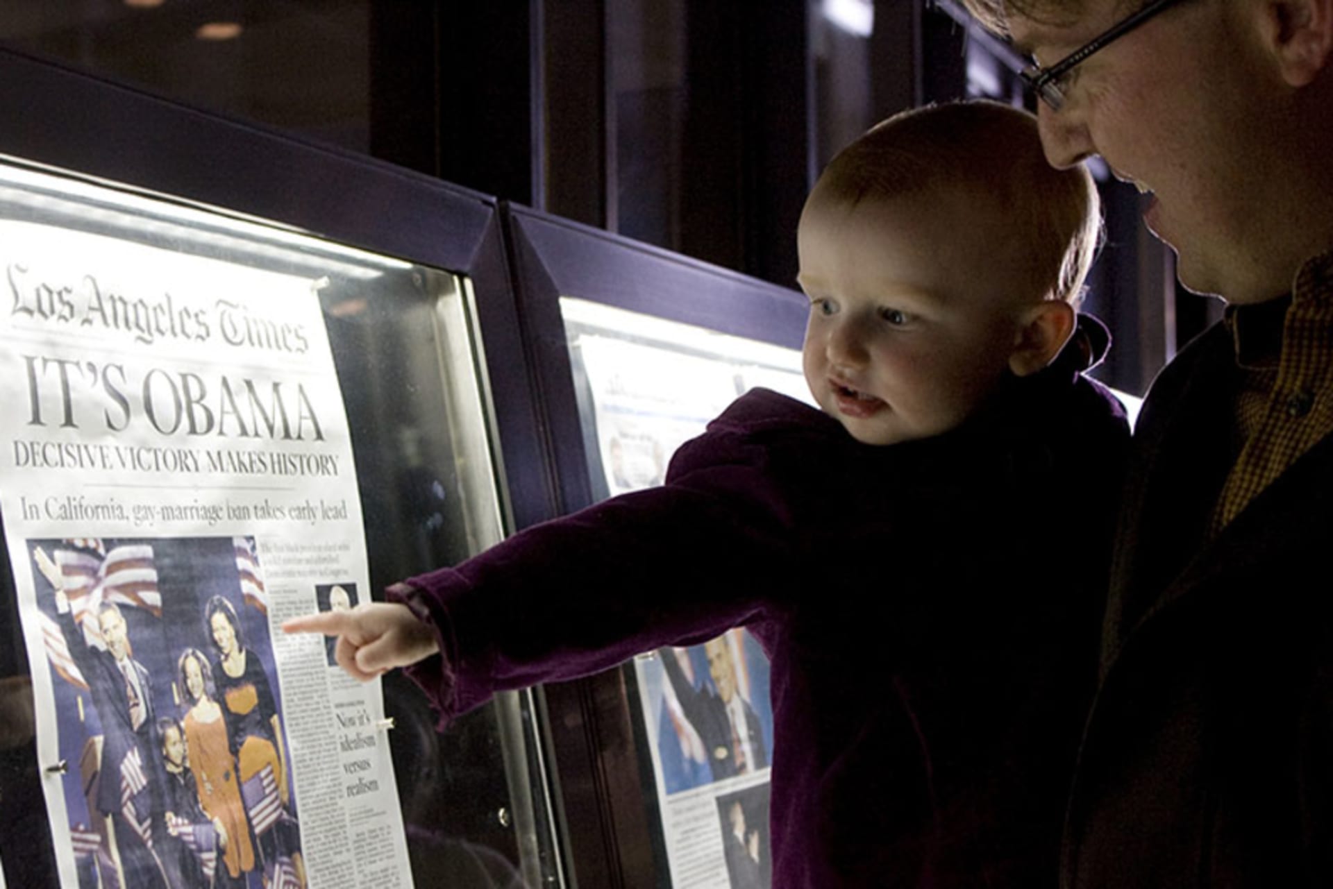 Baby and her father view the front page newspapers after the historic win by Democrat Barack Obama, in the 2008 election