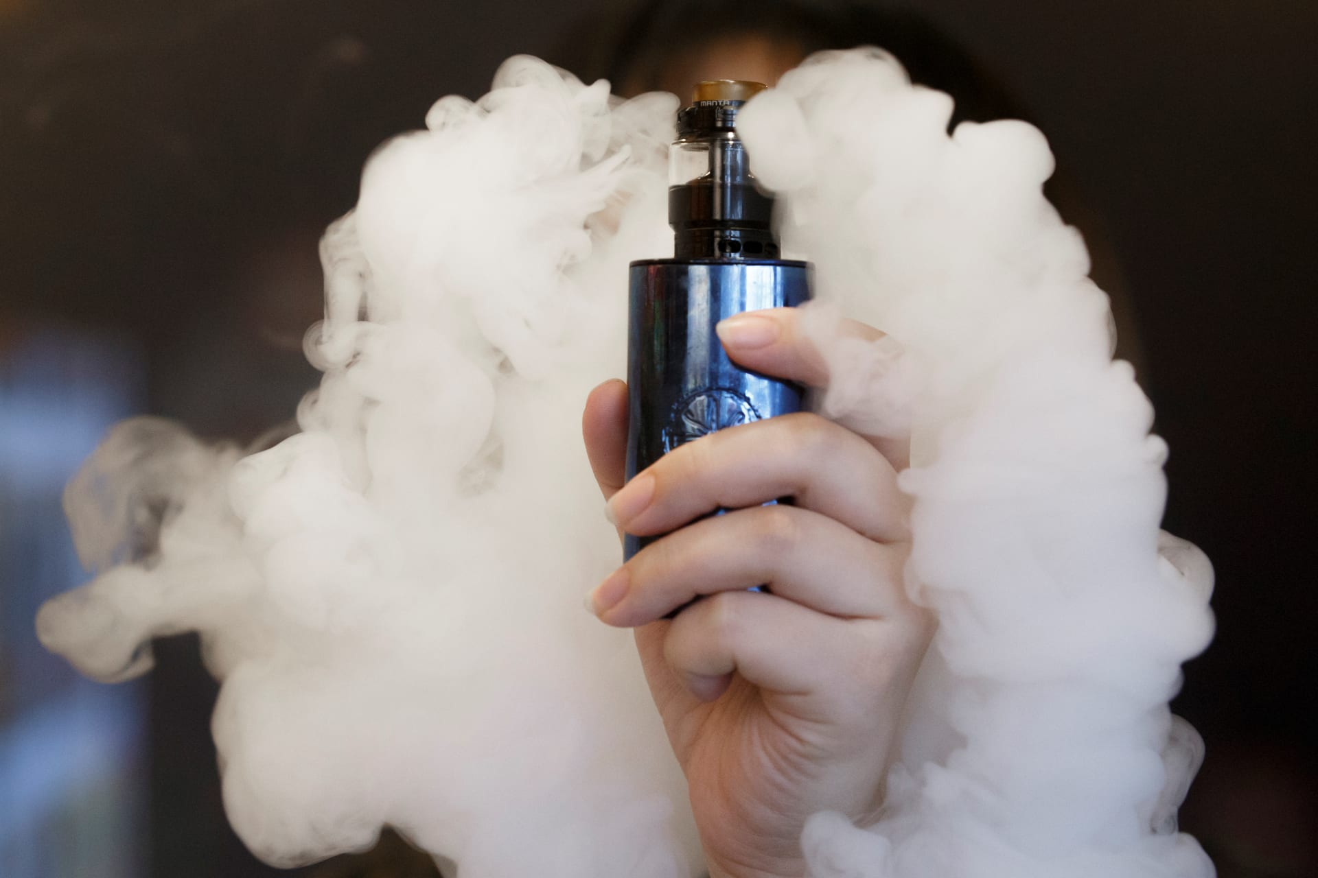 <p>A saleswoman holds an e-cigarette.</p>
