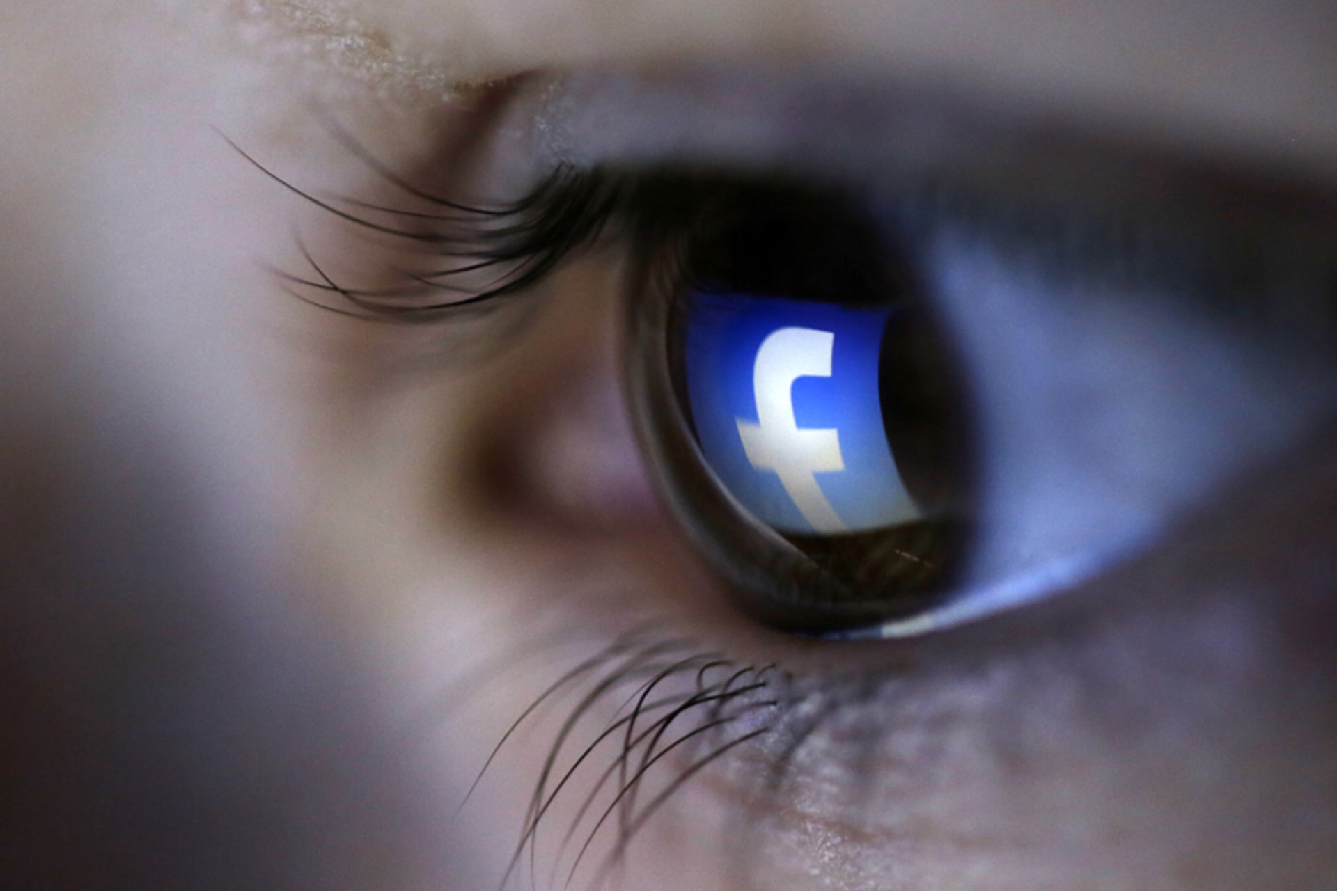 <p>A picture illustration shows a Facebook logo reflected in a person’s eye.</p>