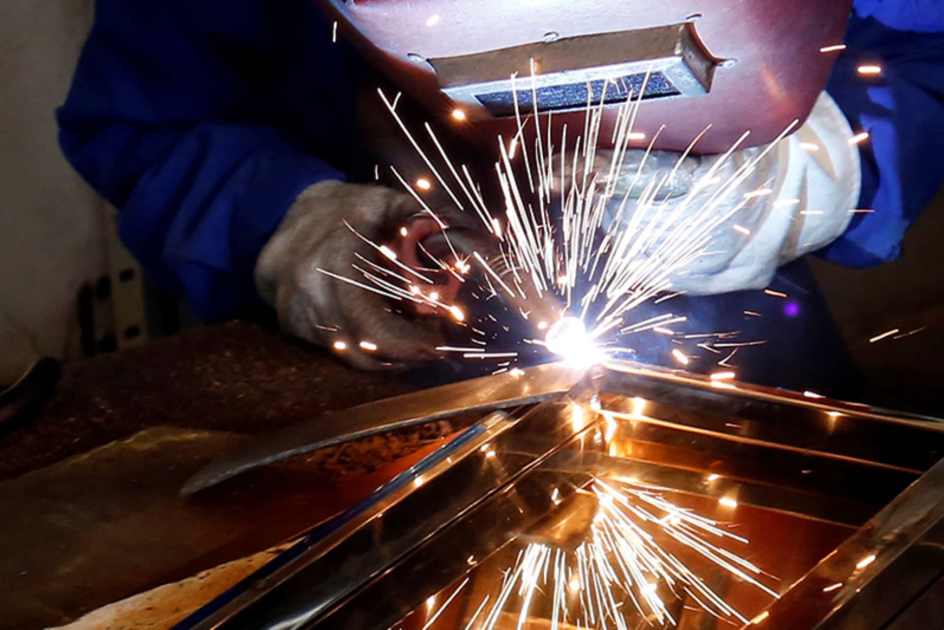 A woman welds a table at Xuan Hoa furniture factory in Xuan Hoa town