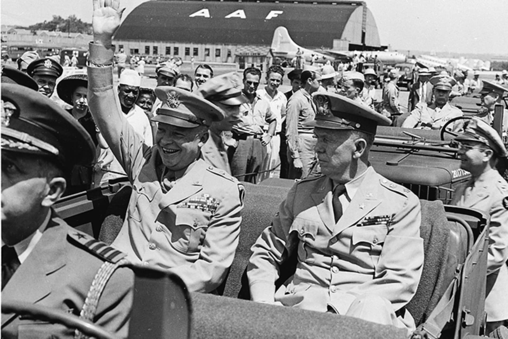 Dwight D. Eisenhower sitting in the back of a jeep with General George C. Marshall
