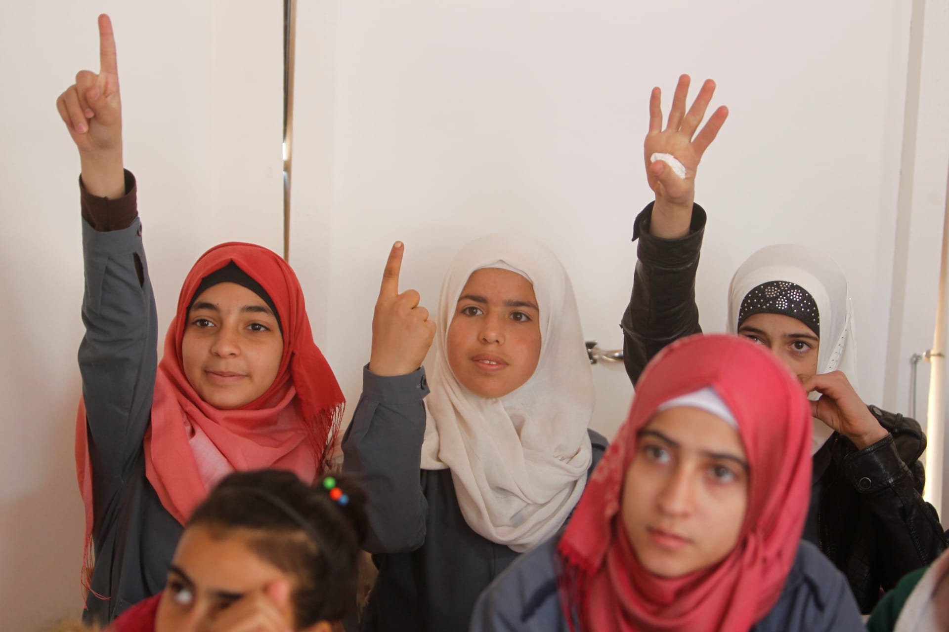 <p>Syrian refugee girls gesture as they sit inside a classroom at a school for Syrian refugee girls in Lebanon, October 19, 2017. </p>
