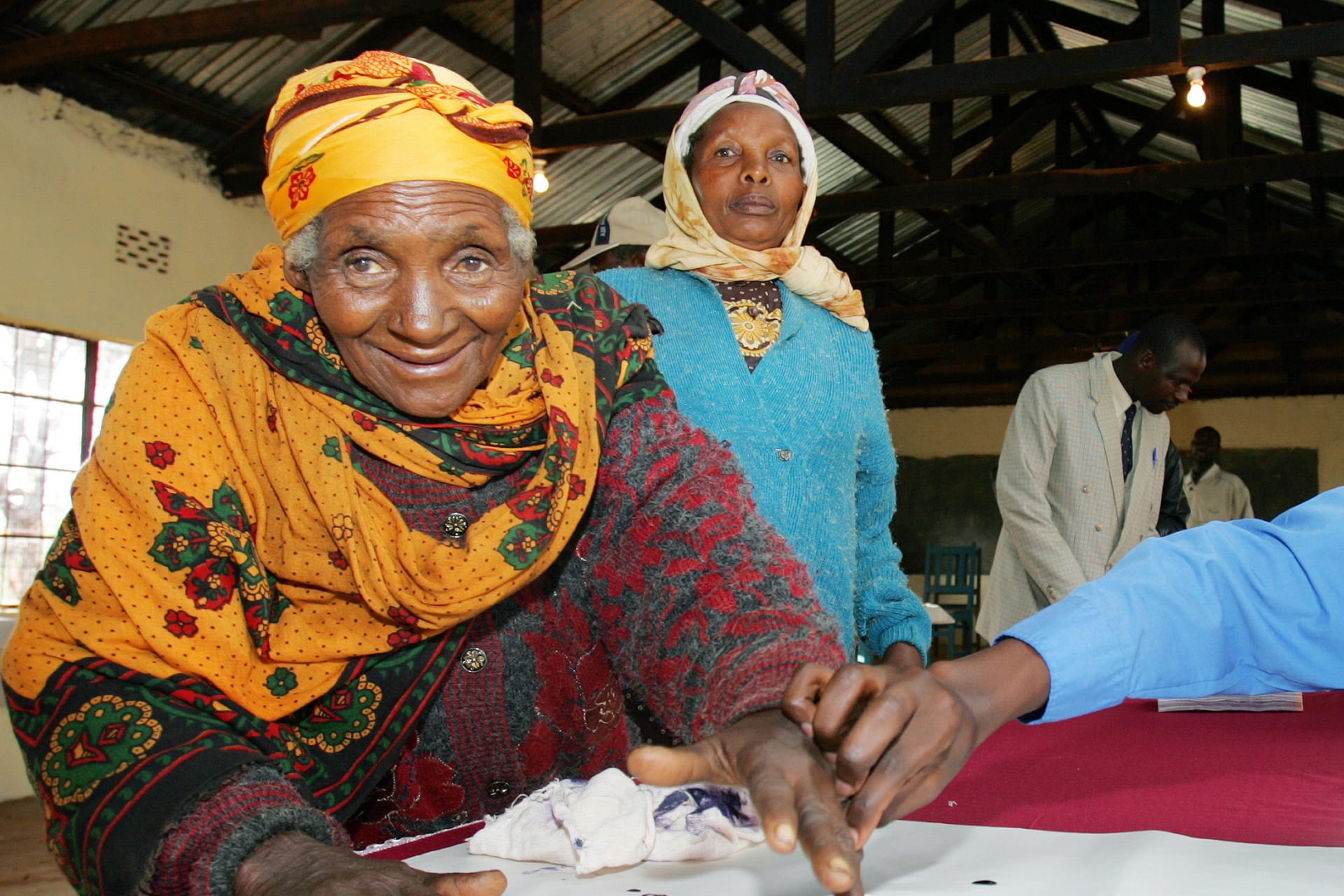 <p>An election official helps a Kenyan woman cast her vote at a polling station in Nyeri district, Kenya November 21, 2005. [</p>