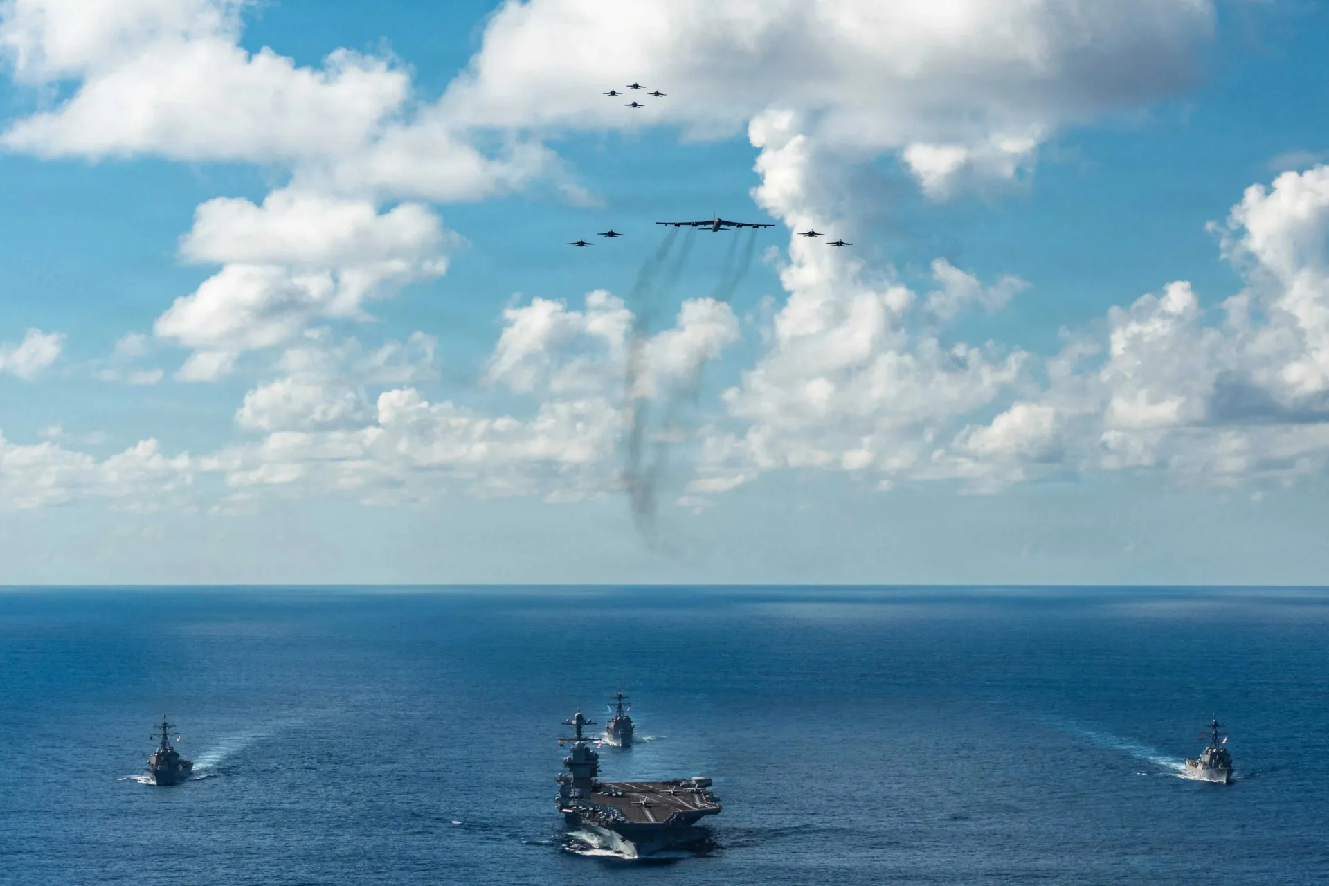 <p>The U.S. Navy’s Gerald R. Ford Carrier Strike Group sails toward the Caribbean Sea under F/A-18E and F/A-18F Super Hornets and a B-52 Stratofortress on November 13, 2025.</p>
