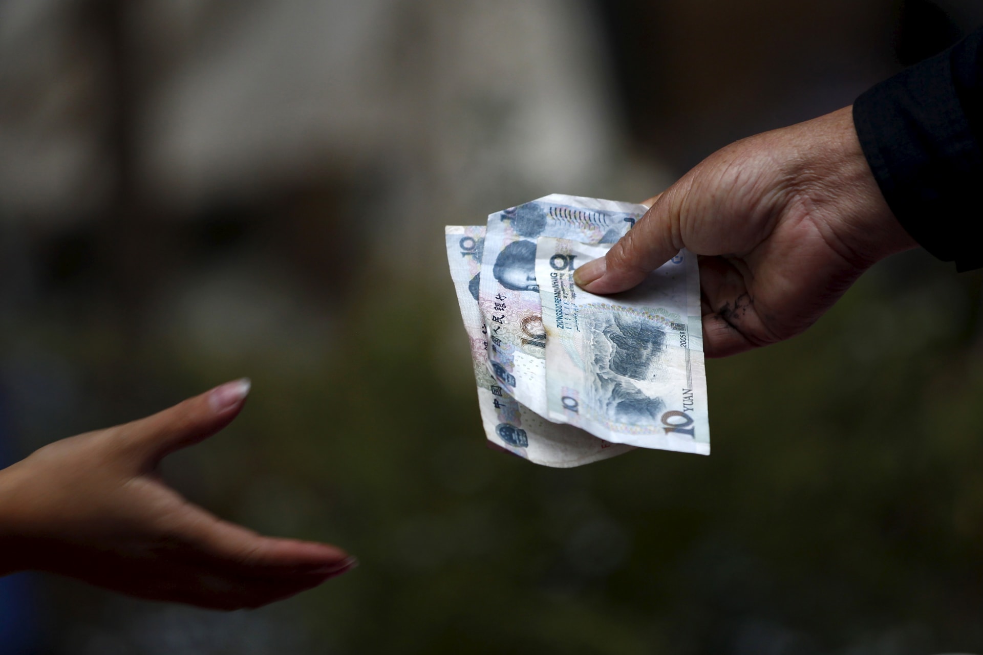 <p>A vendor selling flowers hands over change to a customer</p>
