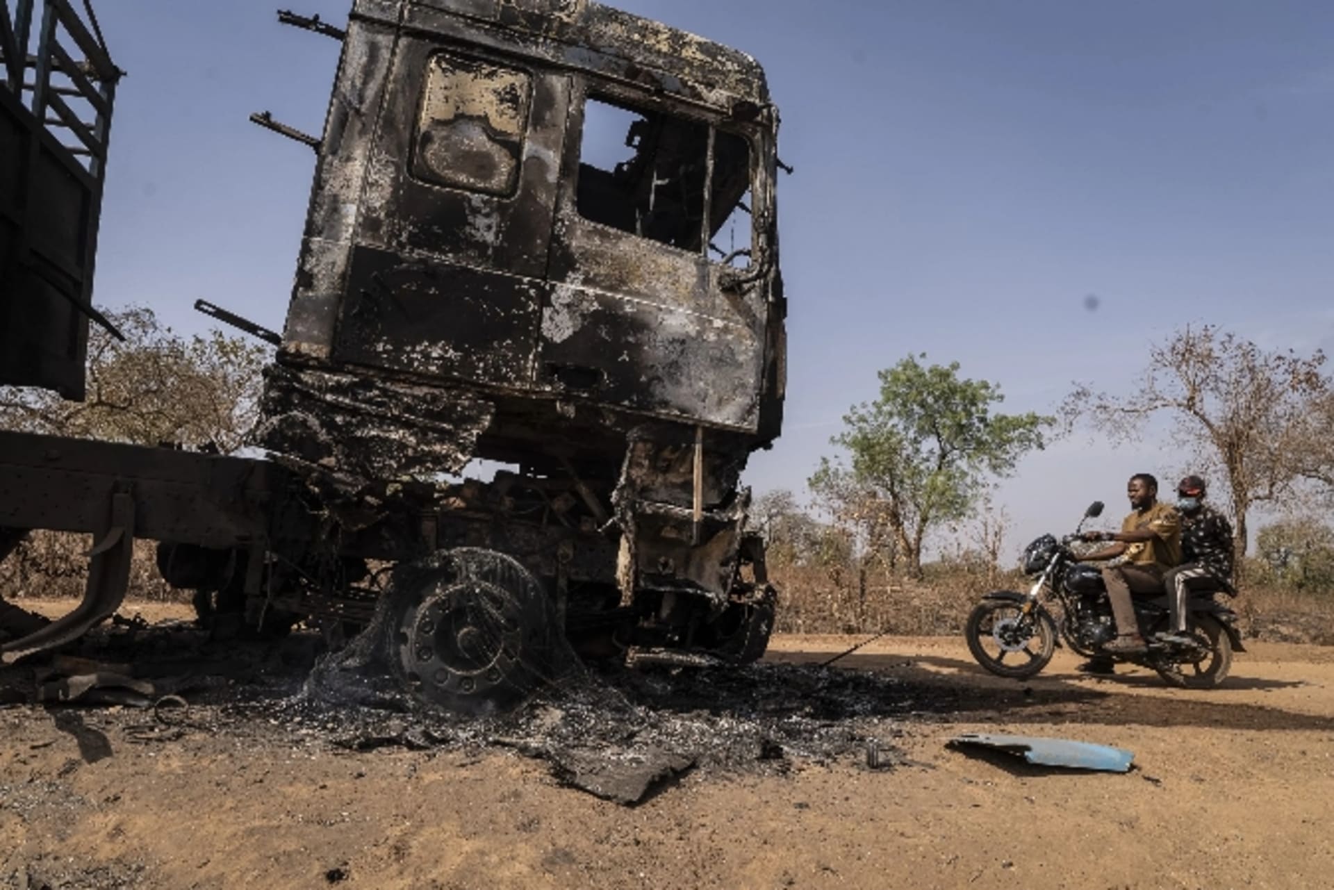 <p>Men ride past a burnt truck following the attack in Woro, Kwara state, Nigeria, on February 5, 2026.</p>
