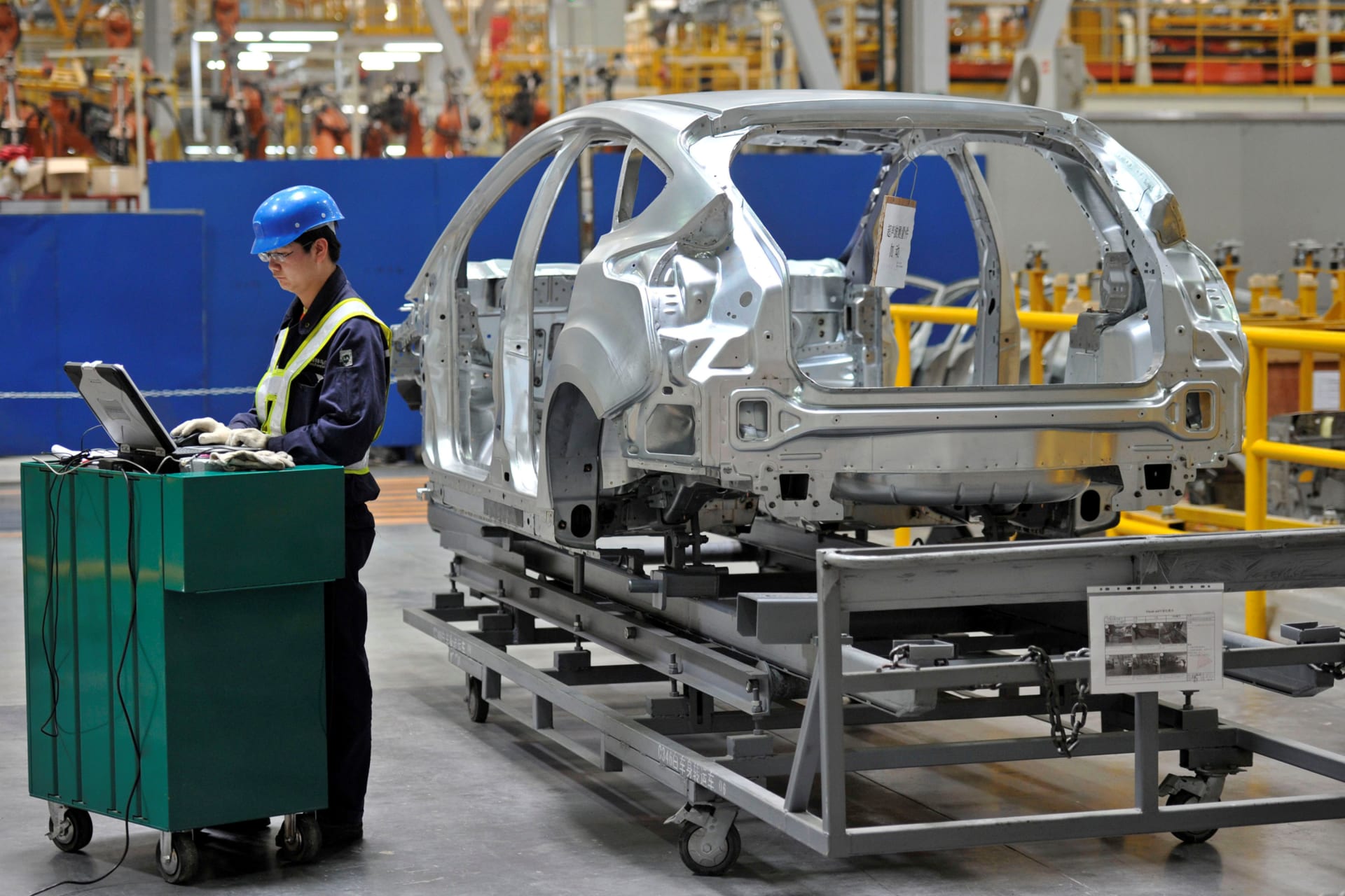 <p>An employee uses a laptop next to a car body at an assembly line at a Ford manufacturing plant in Chongqing municipality April 20, 2012. </p>
