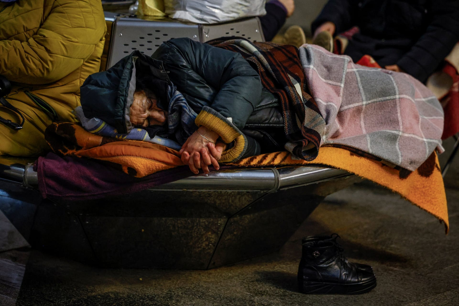 A woman sleeps as she takes shelter inside a metro station during an air raid alert in Kyiv, Ukraine.