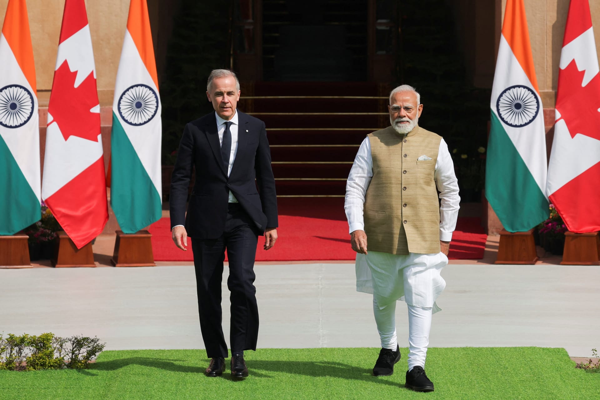 Canada's Prime Minister Mark Carney walks with his Indian counterpart, Narendra Modi, before their meeting at Hyderabad House