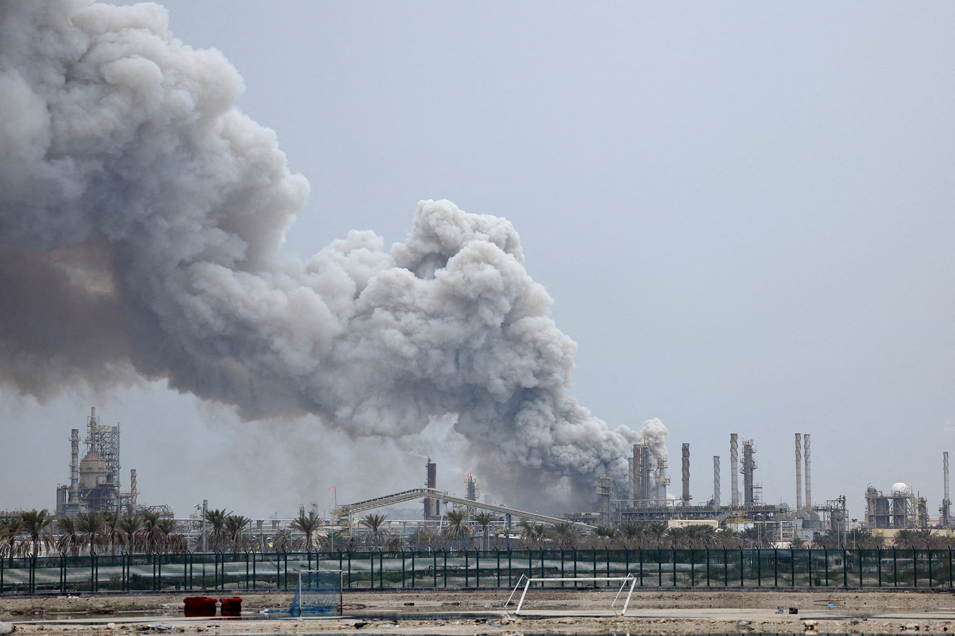 <p>A person rides on a scooter as smoke rises in the Fujairah oil industry zone following a fire caused by debris after interception of a drone by air defenses, in Fujairah, United Arab Emirates, March 3, 2026.</p>
