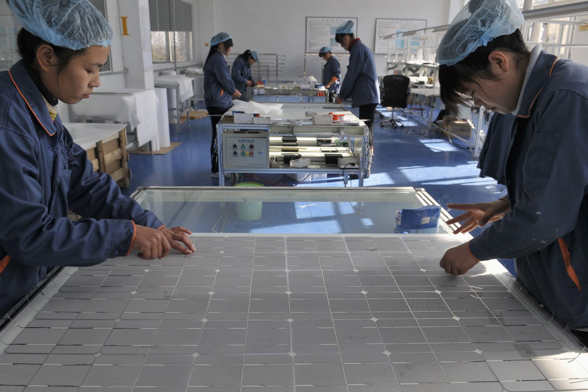 Employees work at the solar cells production line of the Blue Carbon Technology Inc. in Rizhao, Shandong province December 3, 2010. China is considering investments of up to $1.5 trillion over five years in seven strategic industries, sources said, a plan aimed at accelerating the country's transition from the world's supplier of cheap goods to a leading purveyor of high-value technologies. The targeted sectors include alternative energy, biotechnology, new-generation information technology, high-end equipment manufacturing, advanced materials, alternative-fuel cars and energy-saving and environmentally friendly technologies. REUTERS/Stringer (CHINA - Tags: ENERGY ENVIRONMENT BUSINESS) CHINA OUT. NO COMMERCIAL OR EDITORIAL SALES IN CHINA