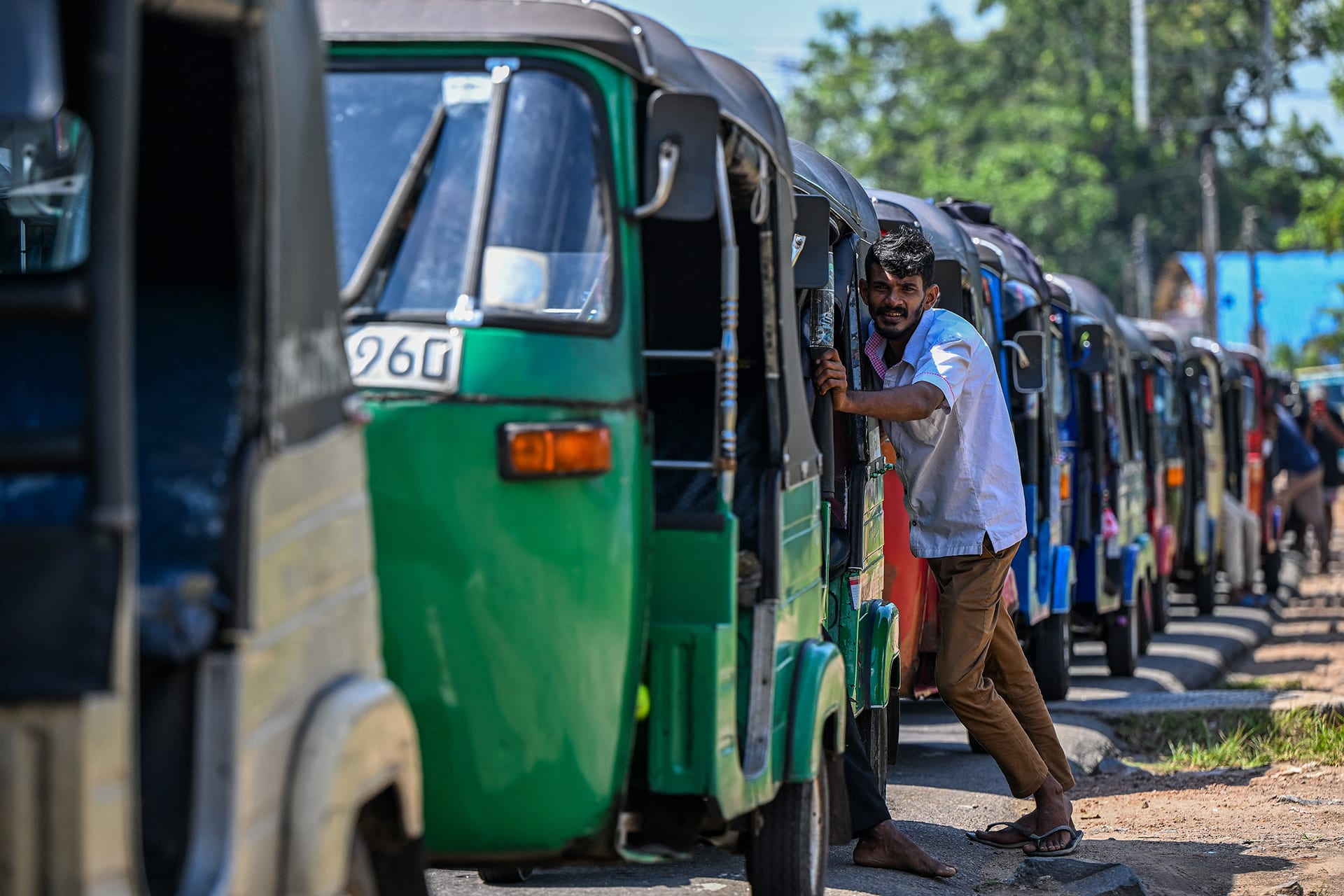 Drivers wait in a queue to refuel their auto rickshaws at a fuel station in Biyagama on the outskirts of Colombo on March 15, 2026. In Sri Lanka