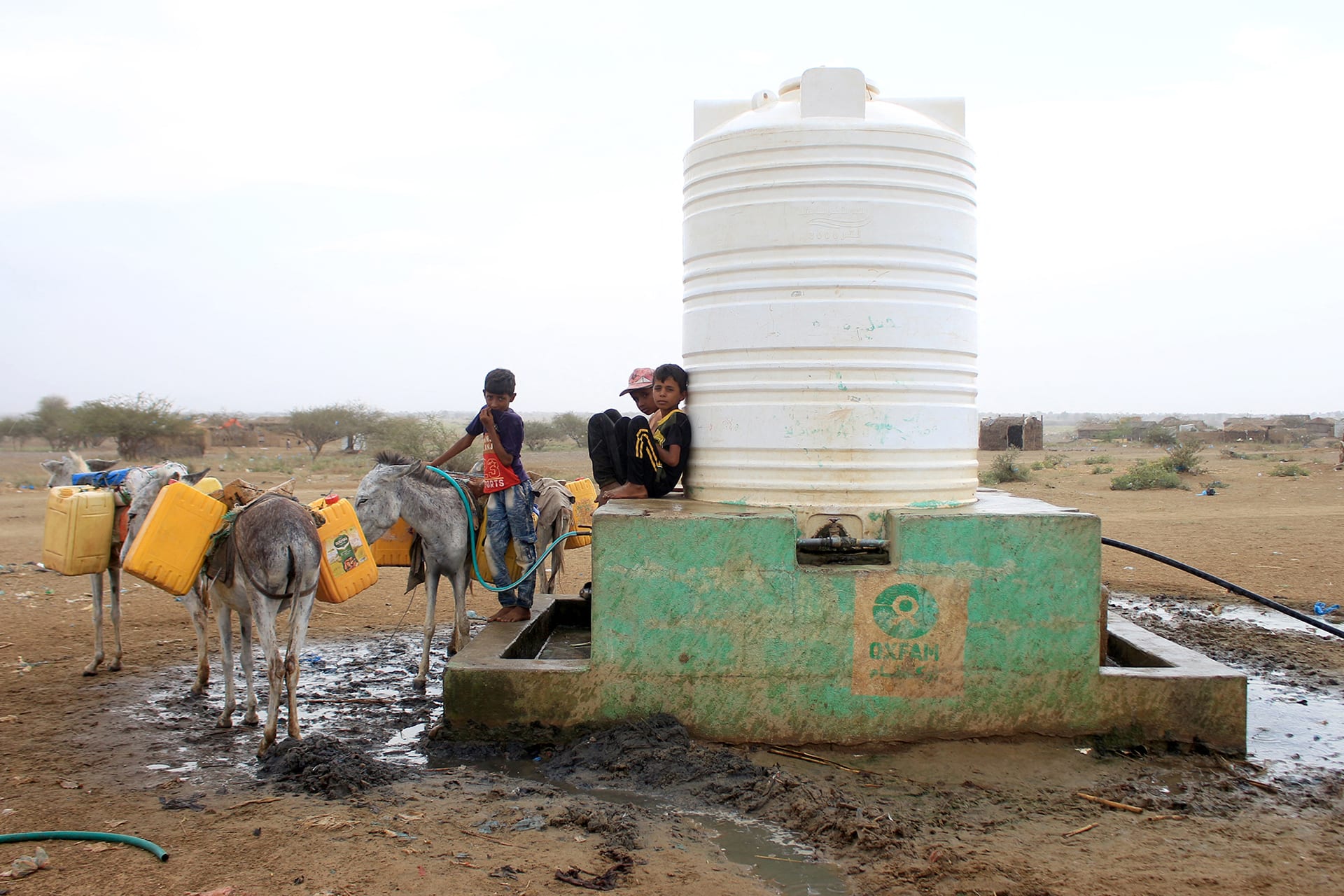 Image of kids fetching water from a tank.