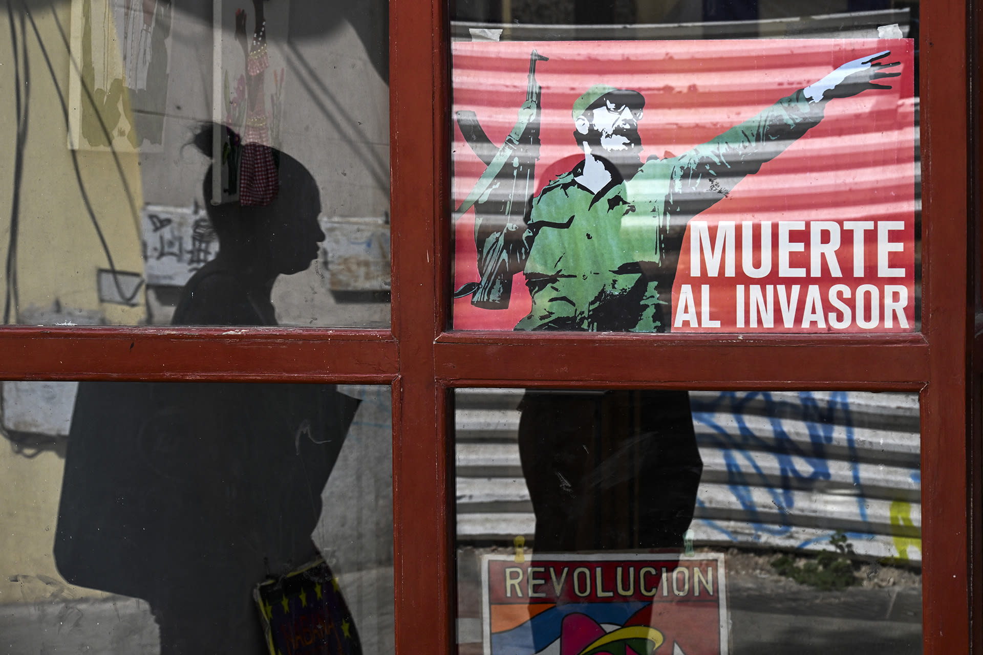 <p>A woman walks past a poster of late Cuban leader Fidel Castro reading, “Death to the invader” in Havana, on March 13, 2026.</p>
