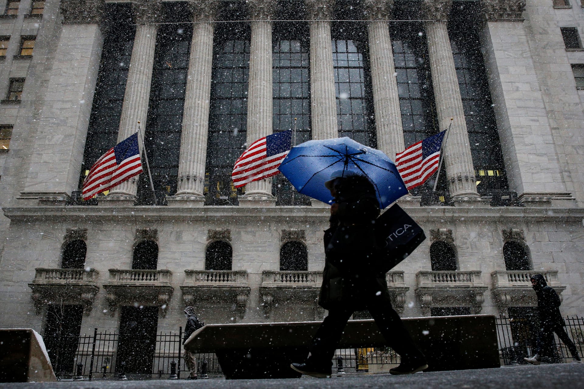<p>Snow beings to fall as morning commuters pass by the New York Stock Exchange in New York, February 7, 2018.</p>
