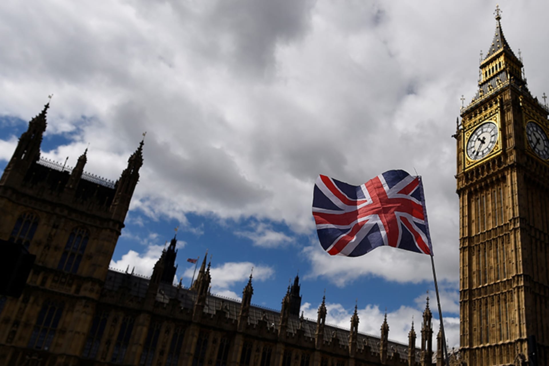<p>The national flag of the United Kingdom flies near the Houses of Parliament the day before a general election in central London, Britain. </p>
