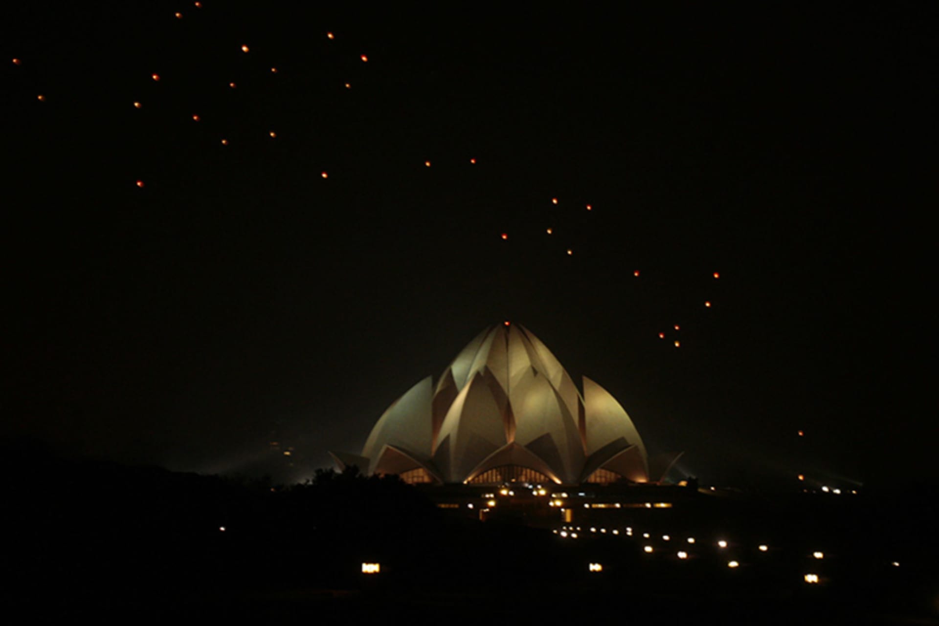 Sky lanterns float over the Lotus Temple in New Delhi