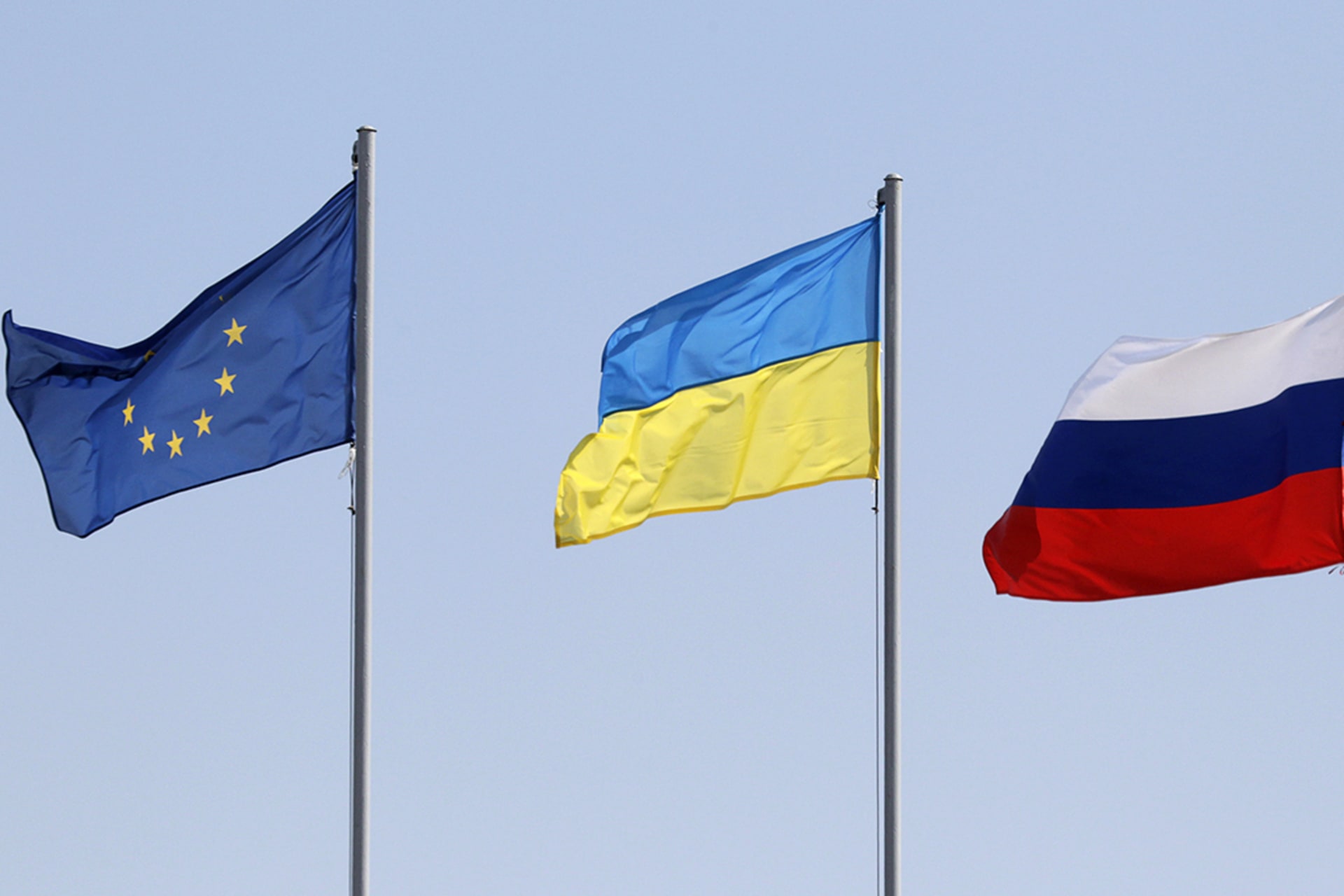 The European Union, Ukranian, and Russian flags flying in a row.