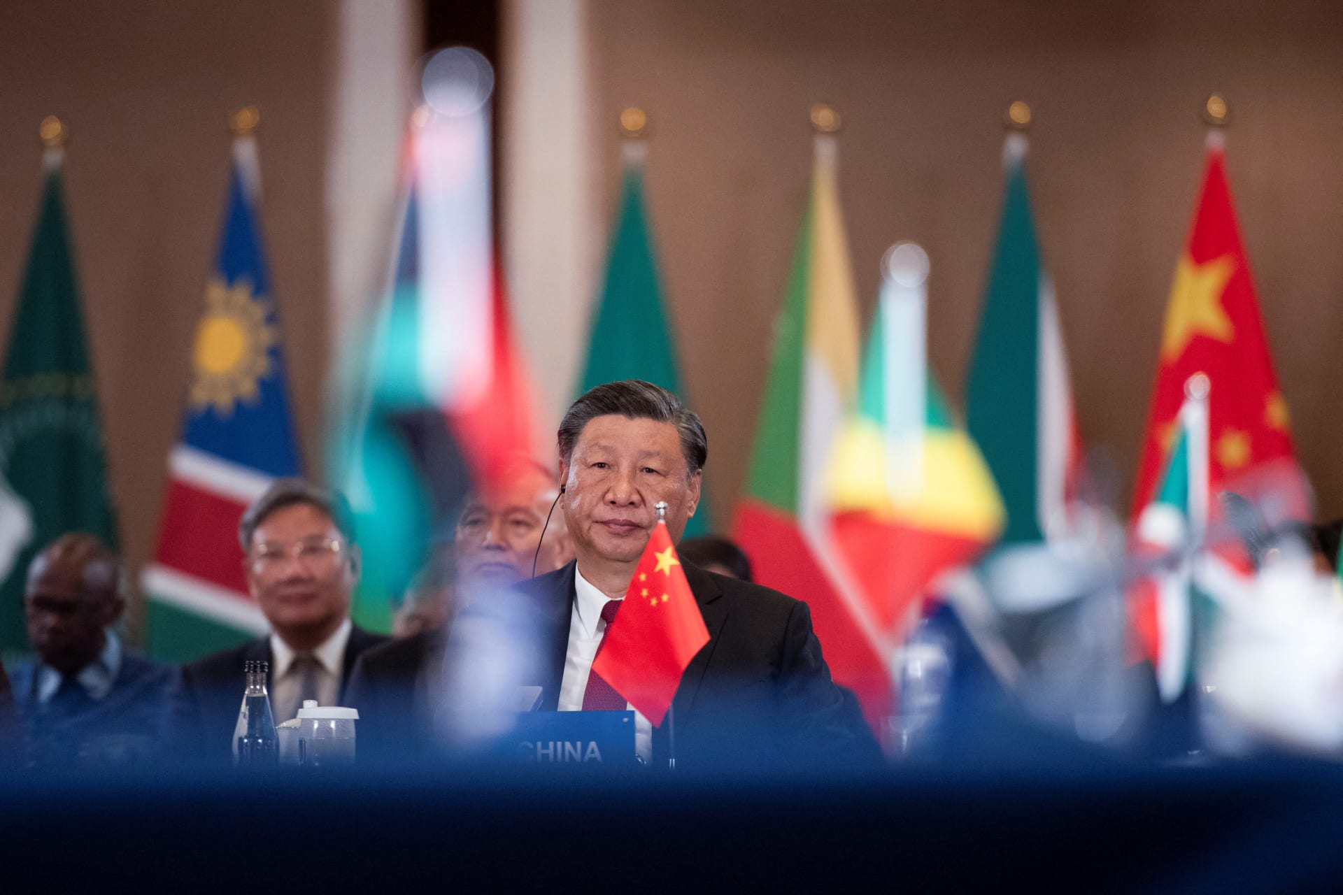 Photograph of Xi Jinping with different flags of African nations behind him.