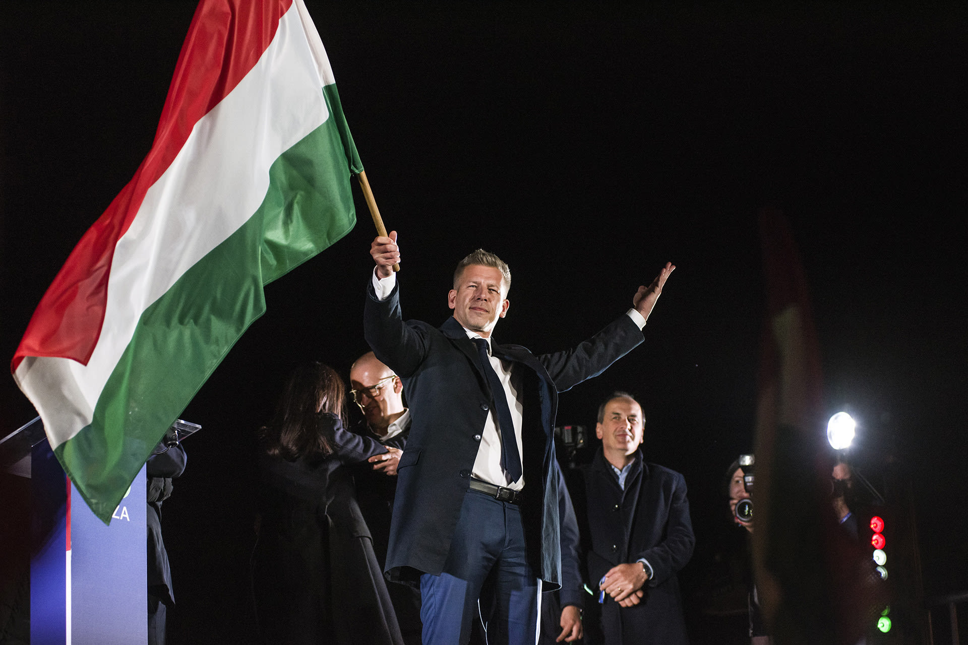 Peter Magyar waves the Hungarian flag after his speech during his party's election night event in Budapest on Sunday, April 12, 2026.