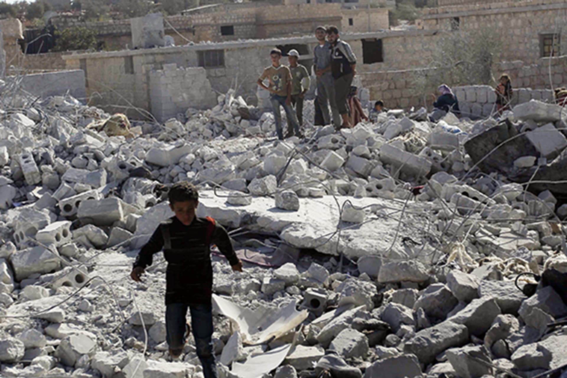 Residents inspect damaged buildings in what activists say was a U.S. strike, in Kfredrian, Idlib Province, Syria, on September 23, 2014.