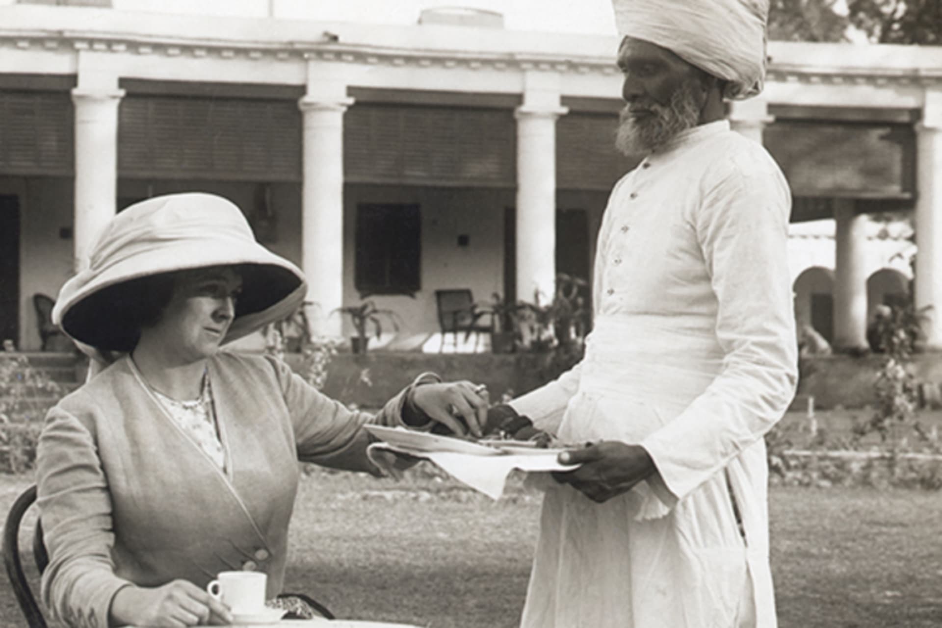 A Hindu servant serves tea to a European colonial woman in this undated photograph.