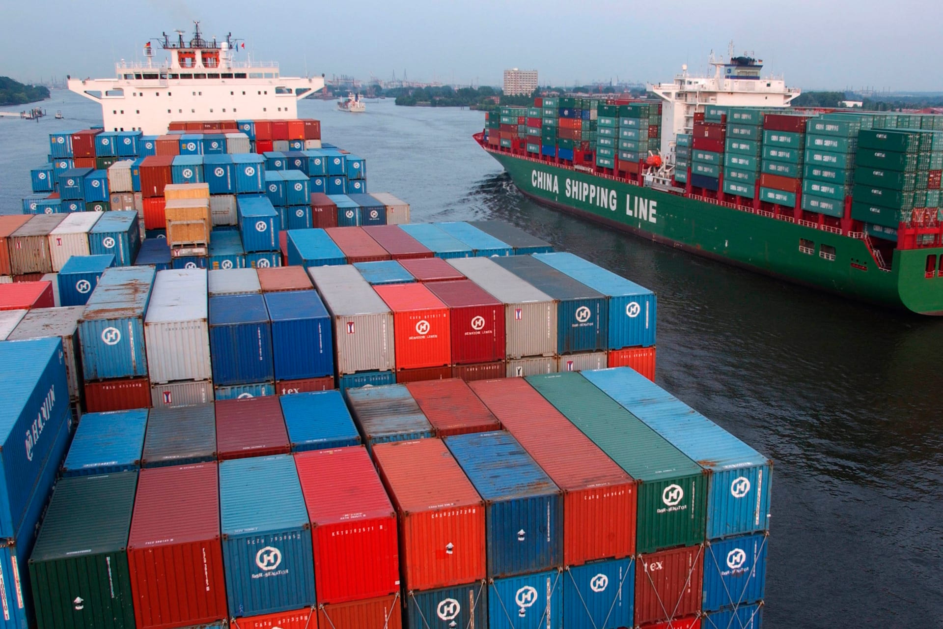 Container ships from China passing at Blankenese on the Elbe, Germany.
