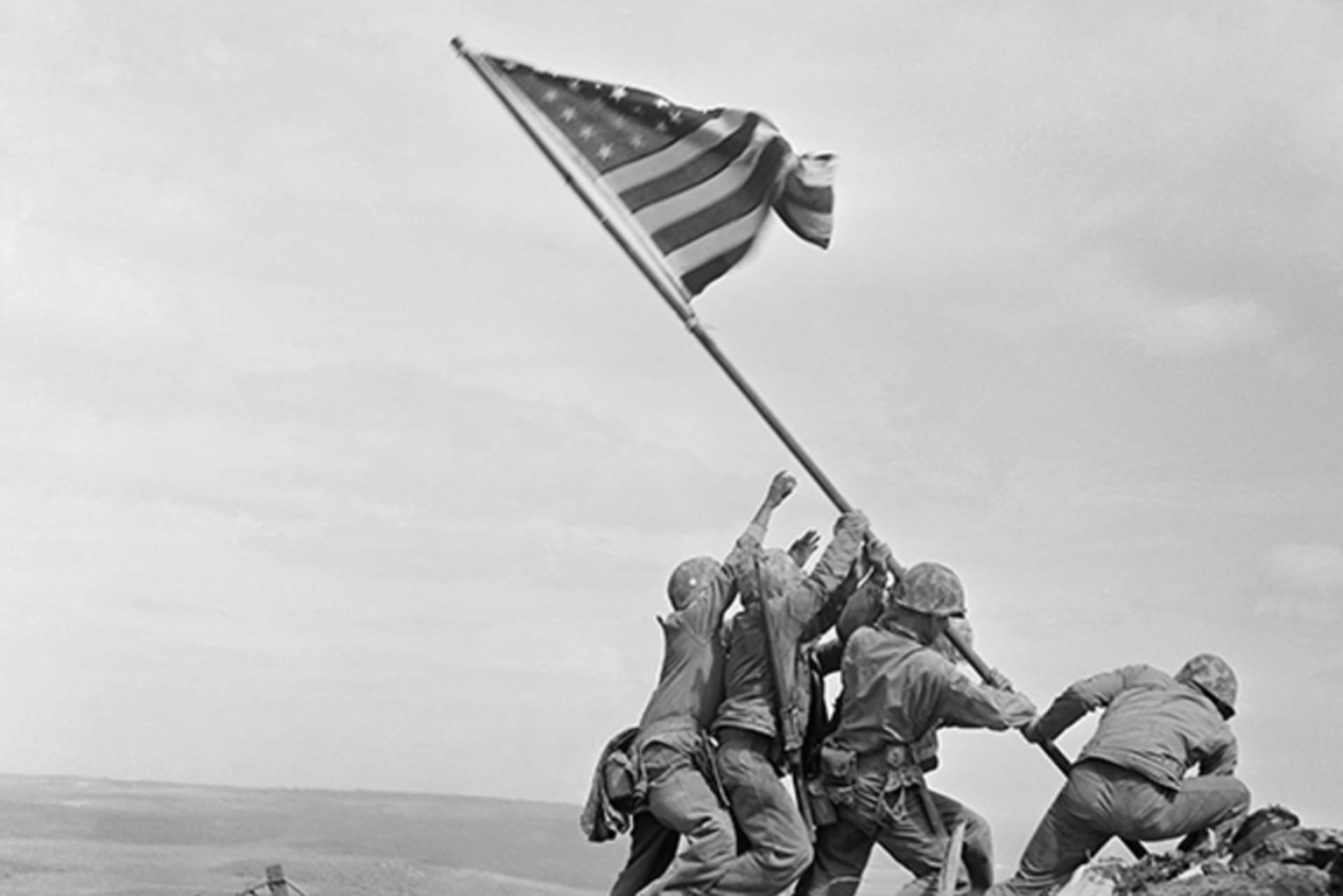 Marines raise the U.S. flag atop Mount Suribachi during the Battle of Iwo Jima on February 23, 1945.