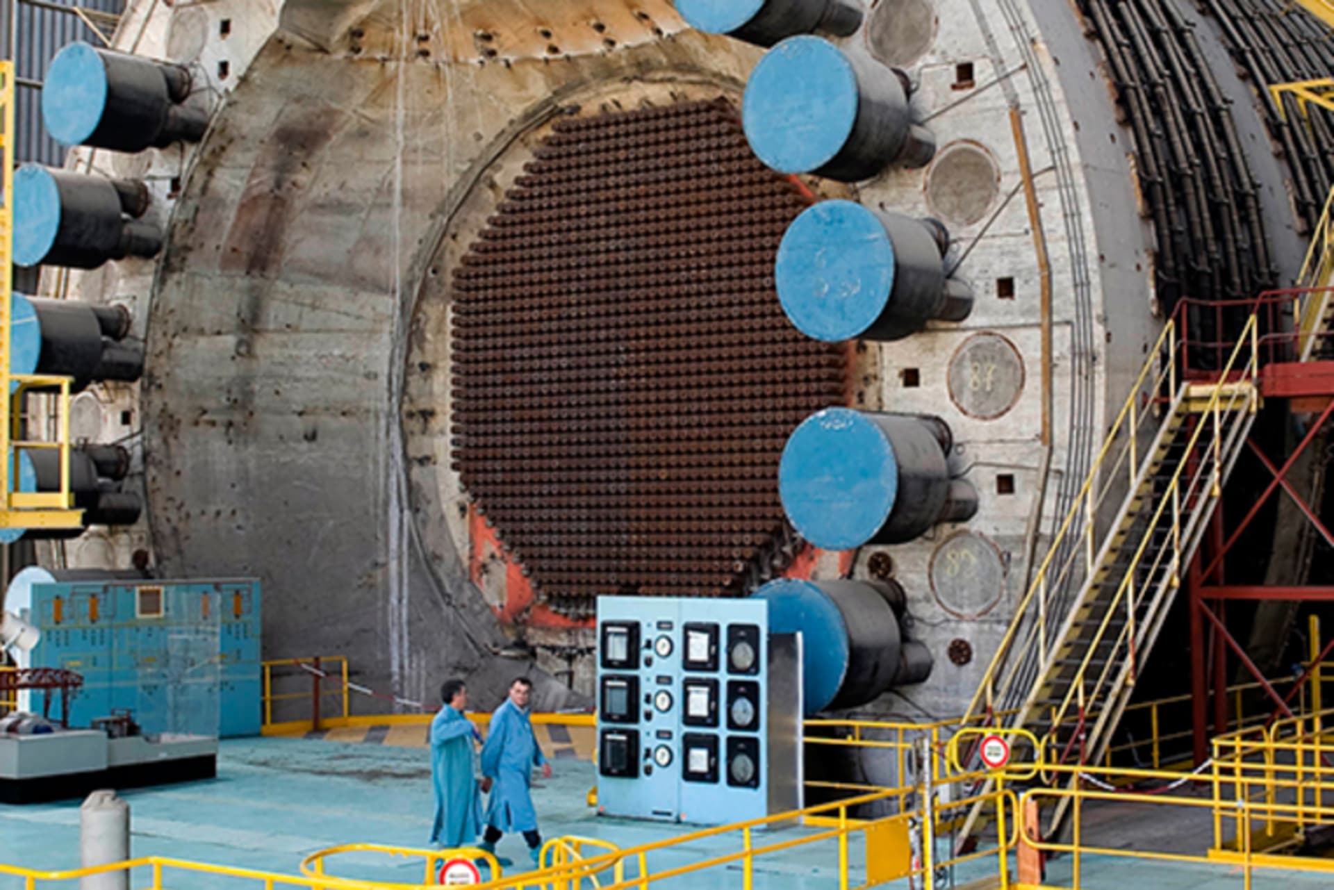 Two employees walk past a reactor at the Marcoule nuclear site in southeastern France.