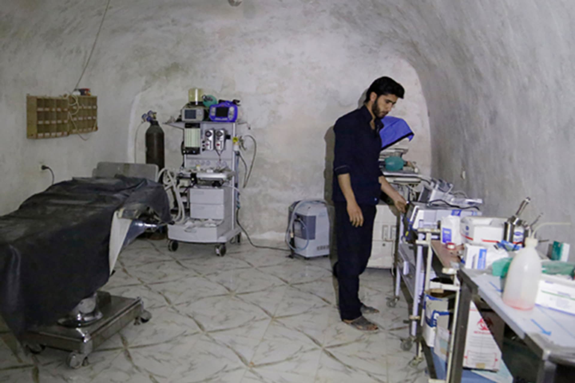 A medic stands at the operation room of a field hospital which was set inside a cave in the town of al-Latamna, in the northern countryside of Hama, Syria, on March 9, 2015.