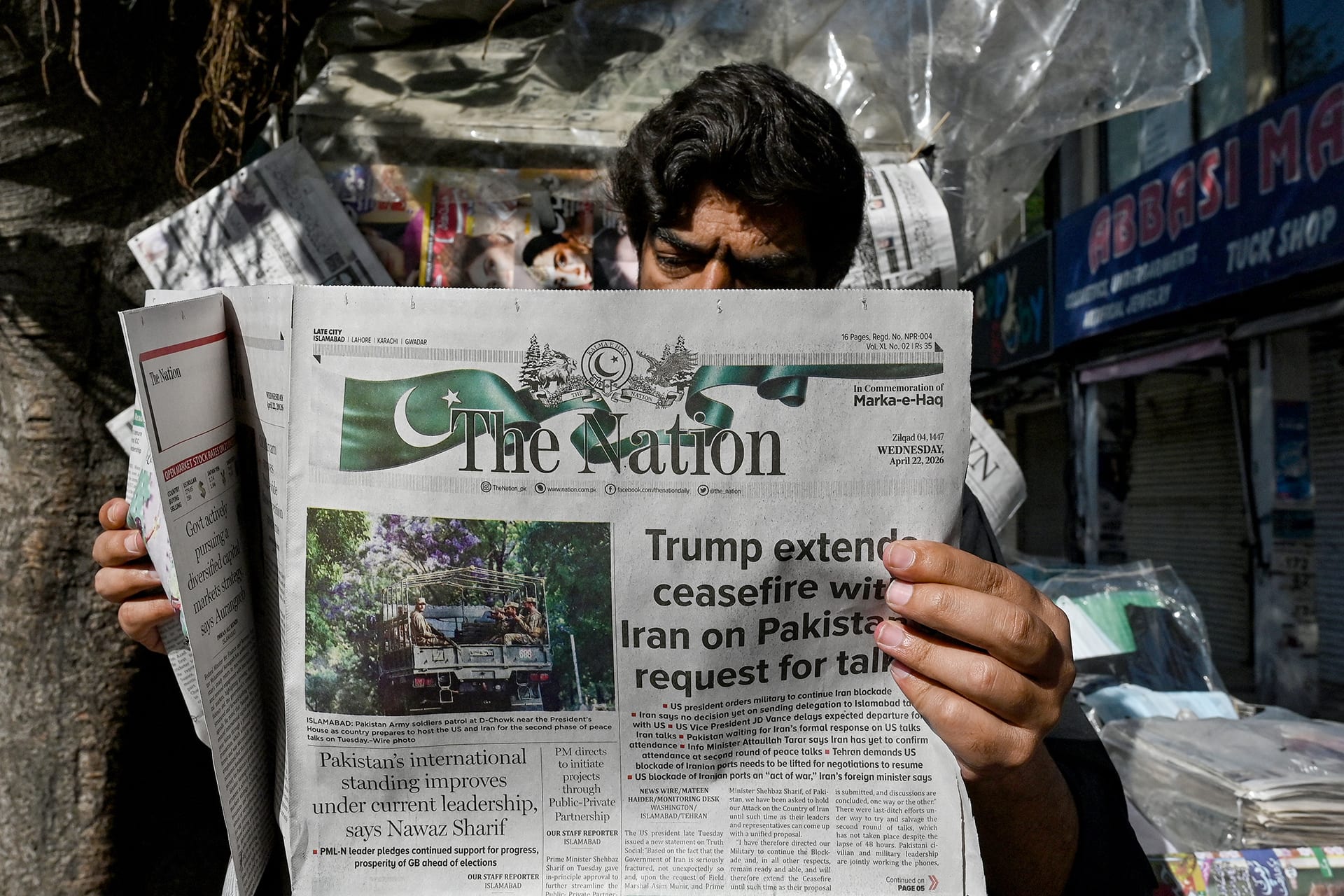<p>A man reads a newspaper with a front page article referring to anticipated US-Iran peace talks, at a stall in Islamabad on April 22, 2026. </p>
