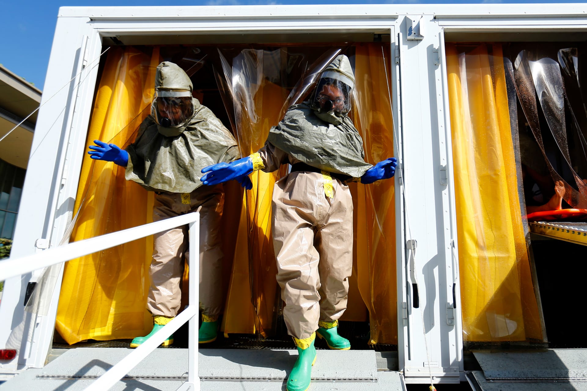 Employees at Palomar Medical Center leave a decontamination trailer during a drill outside their hospital in Escondido, California