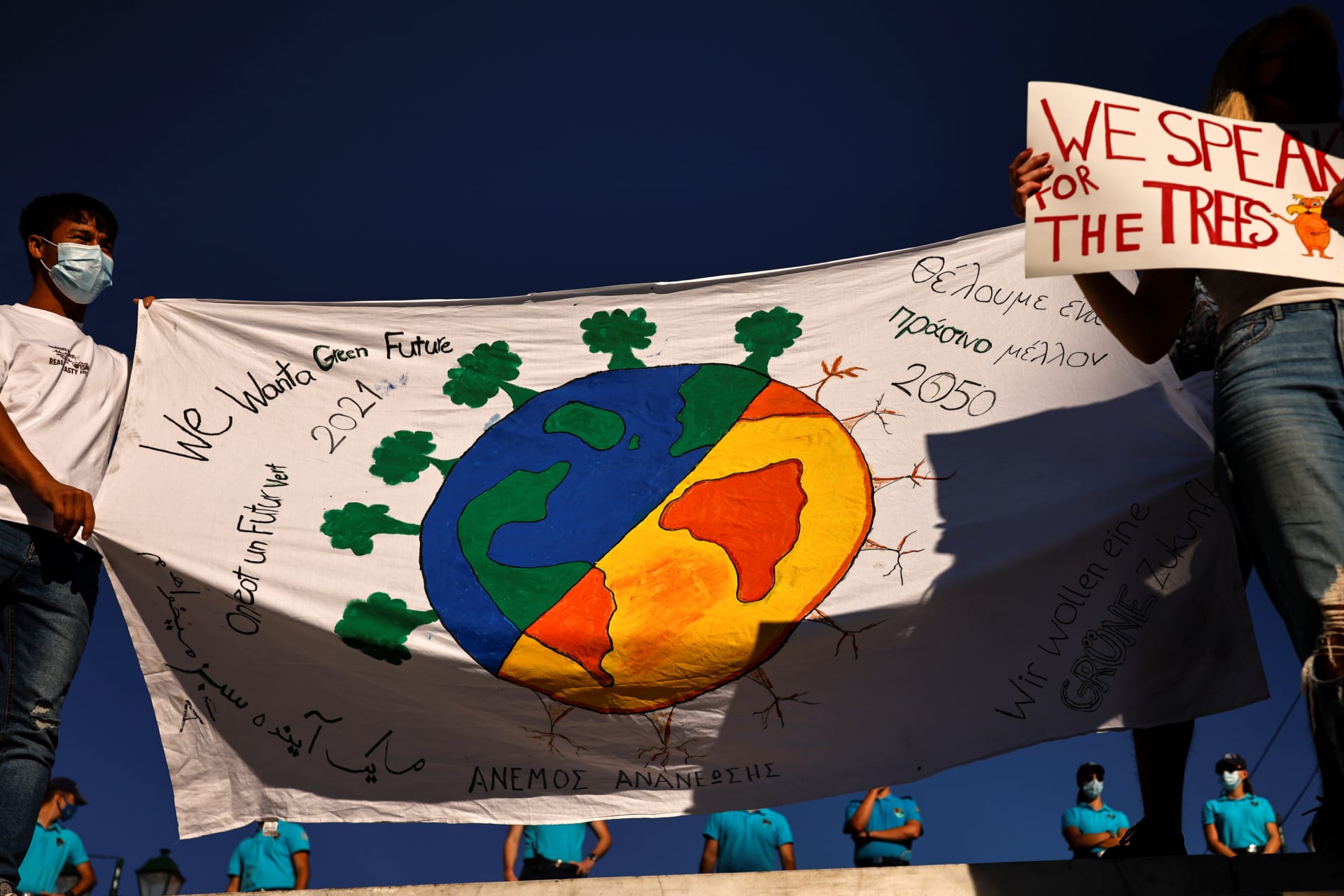 Greek students and activists of environmental organisations hold placards, as police stand guard during a Global Climate Strike rally of the movement Fridays for Future, in Athens, Greece